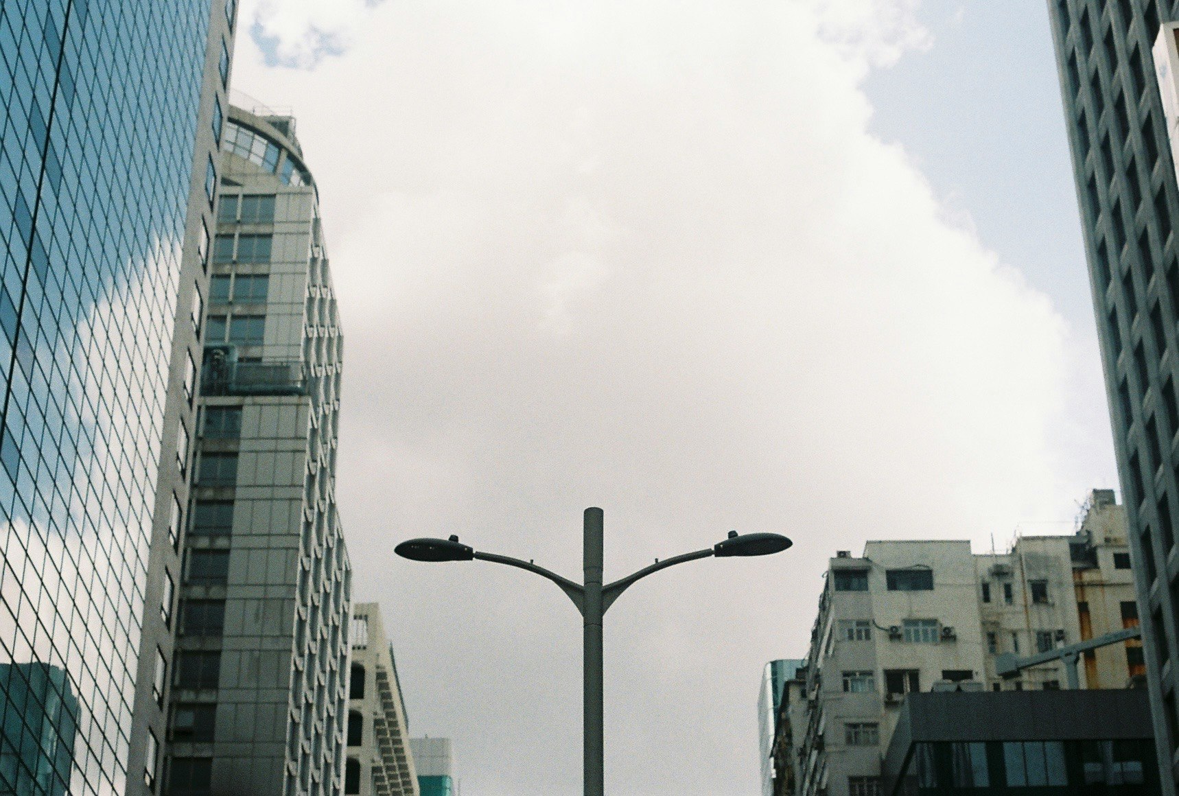 streetlamp framed by tall buildings and sky