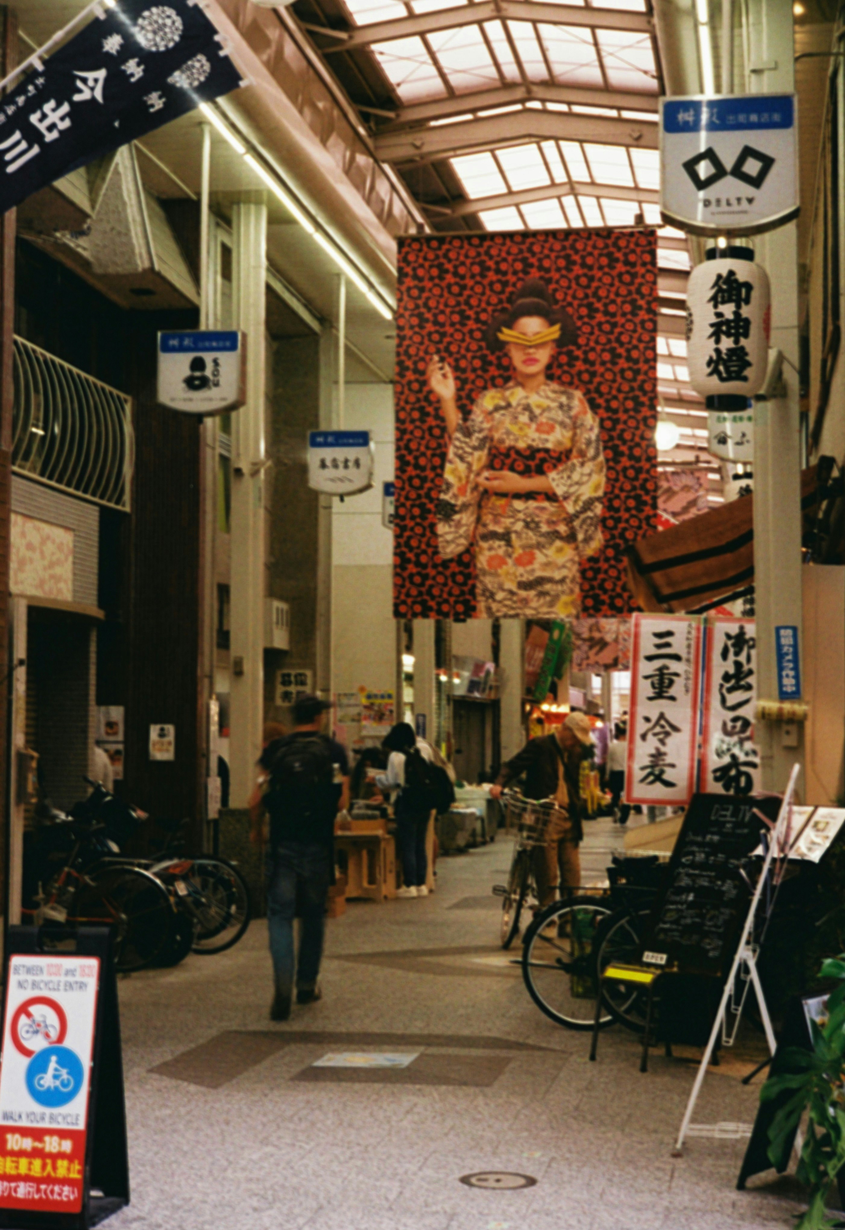 Bicycles and lanterns along a narrow shopping alley in Demachimasugata