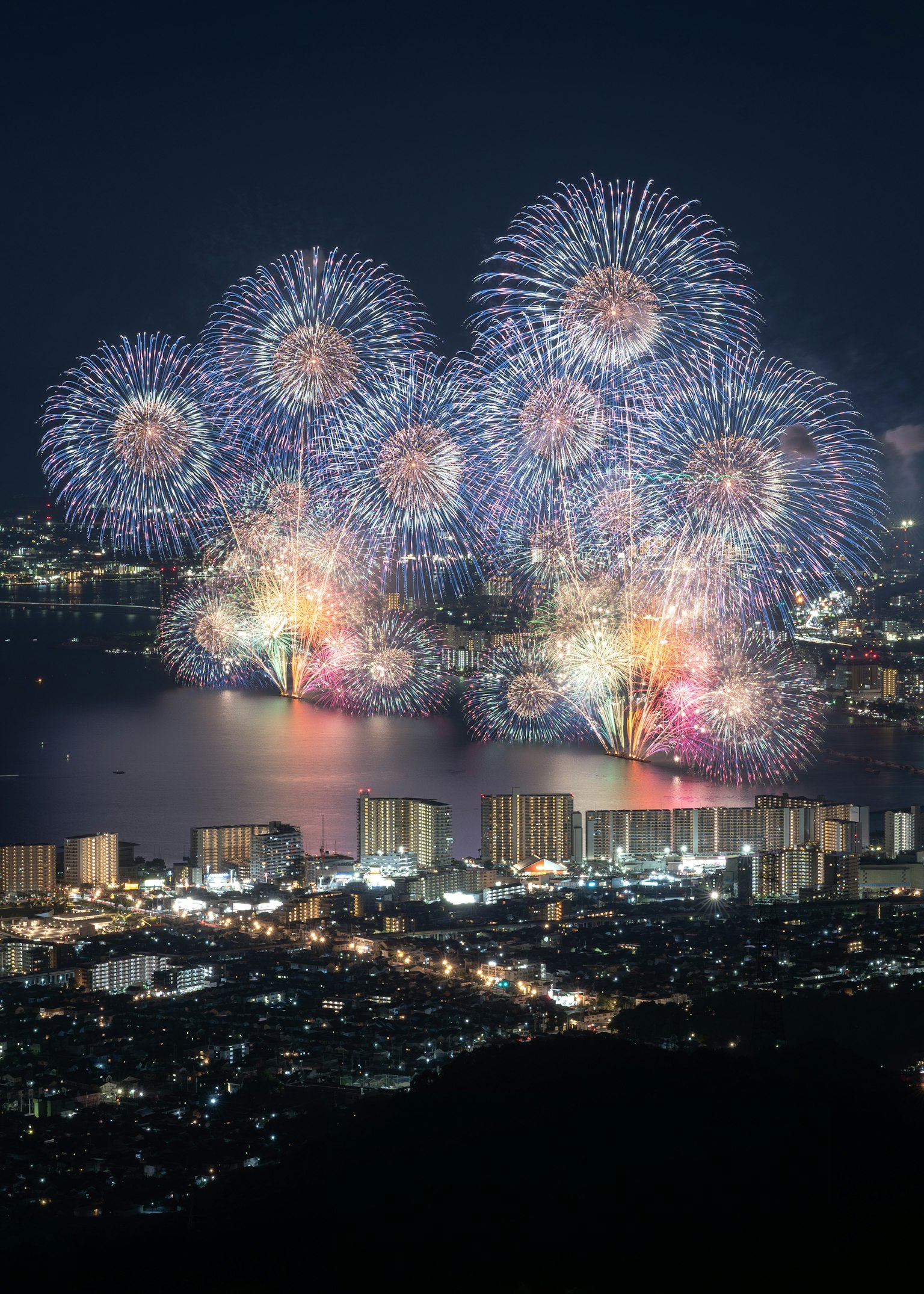 Espectáculo de fuegos artificiales coloridos sobre un horizonte urbano de noche