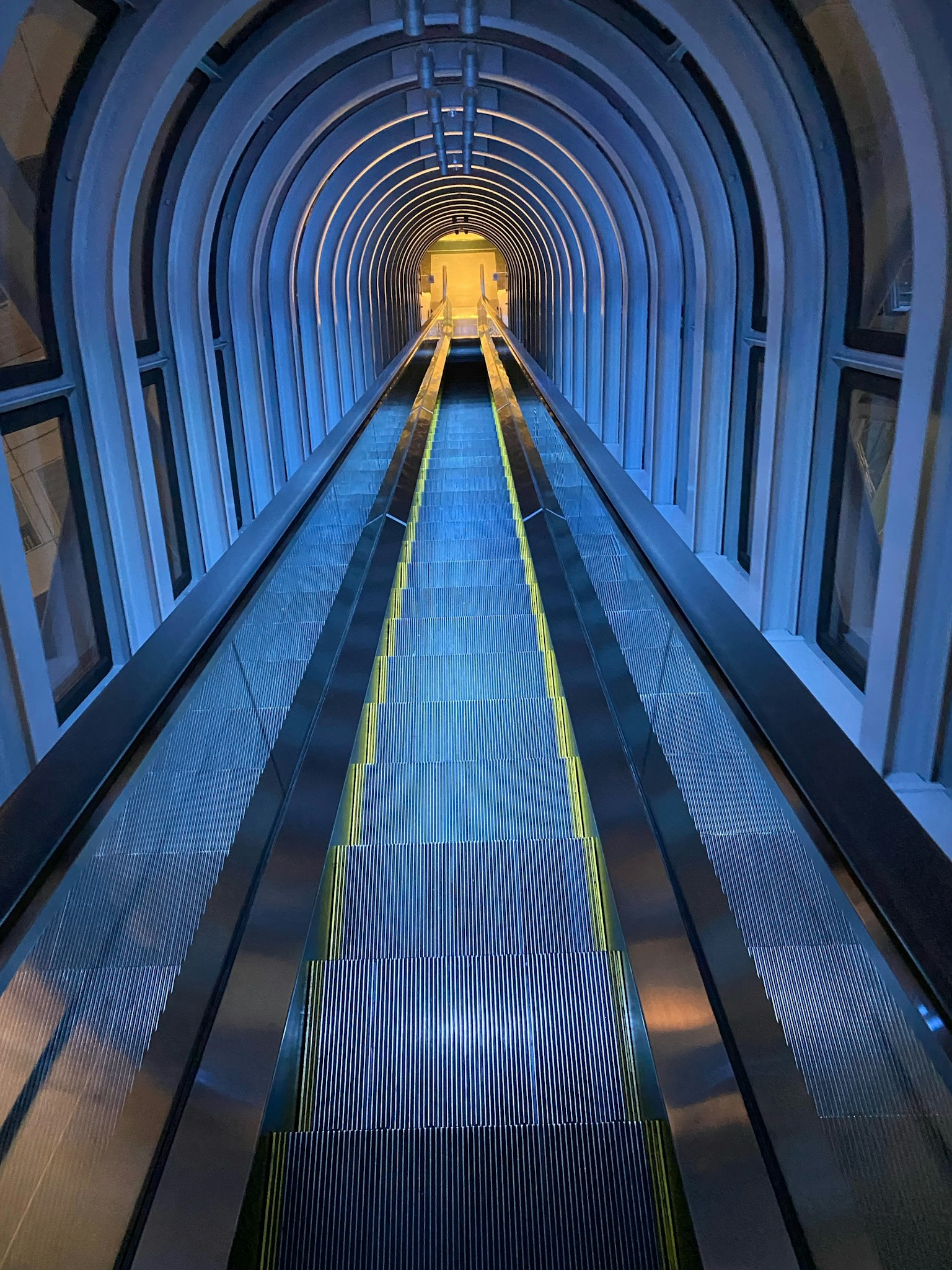 Intérieur d'un escalator en forme de tunnel avec un éclairage bleu
