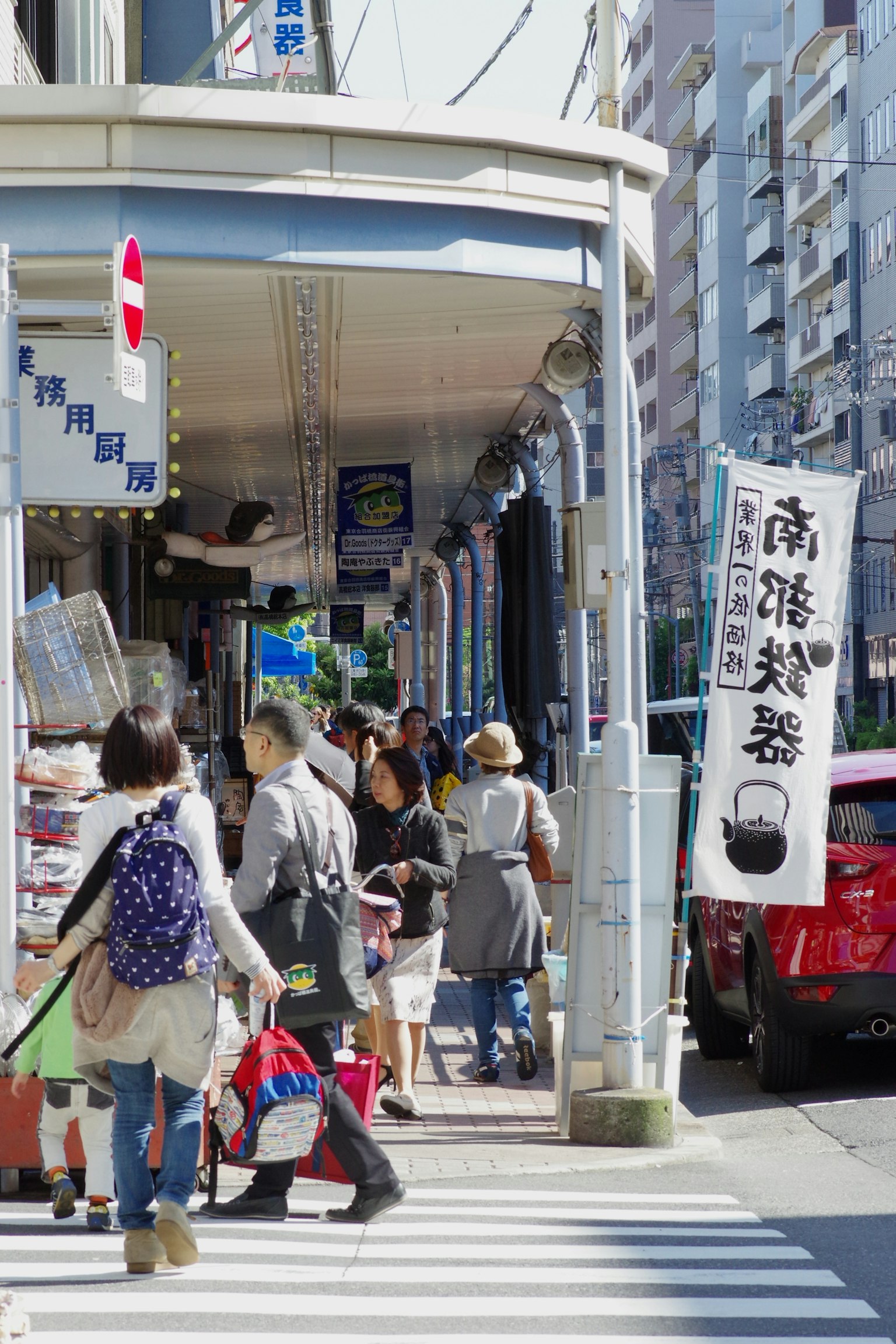 A bustling street scene with people walking in a shopping area