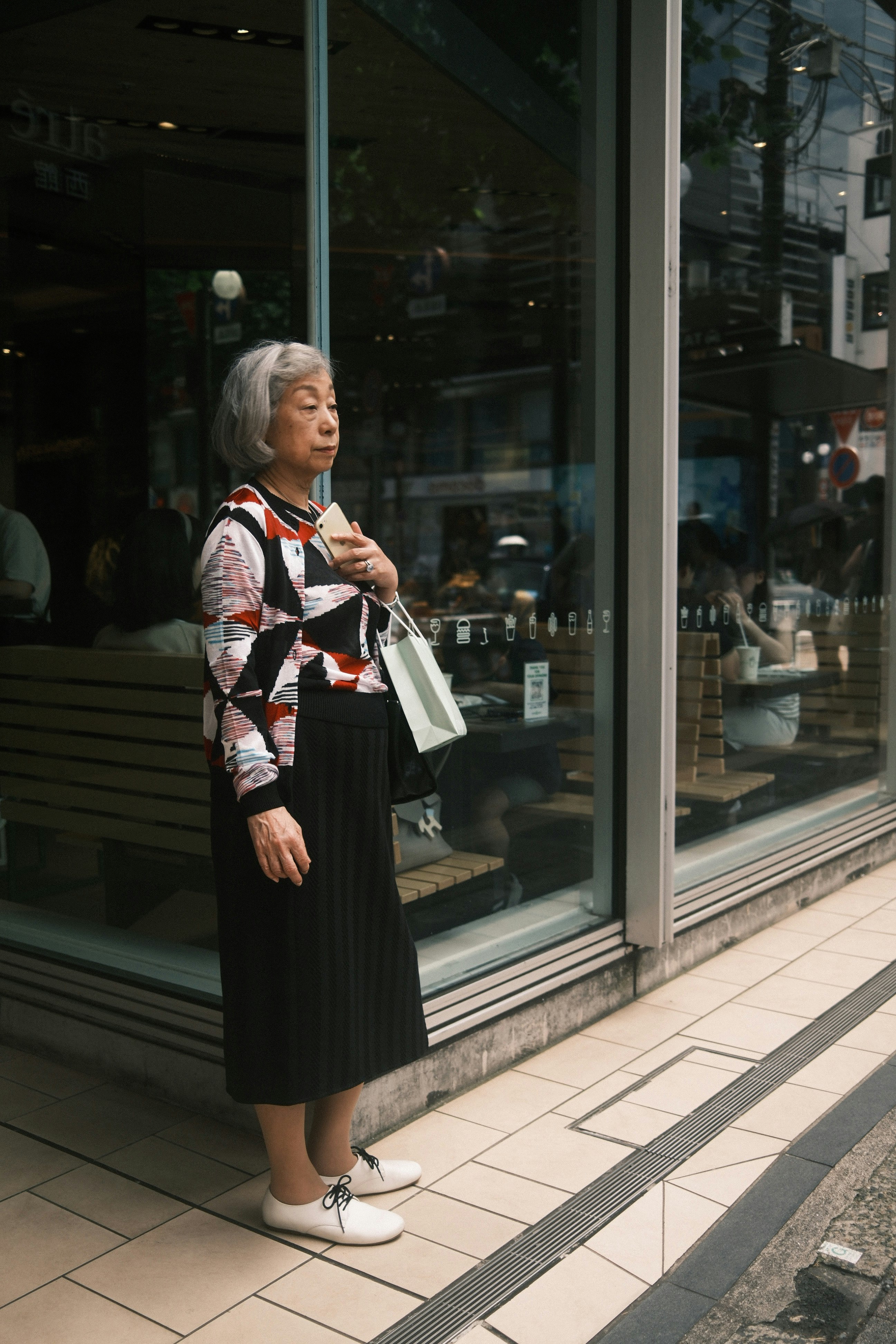 初夏の街角で買い物袋を持つ女性