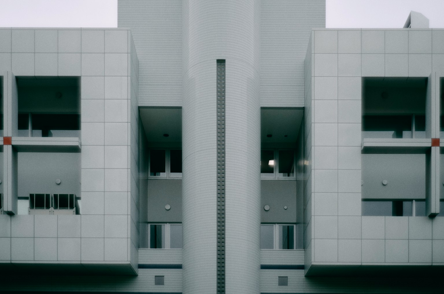 Façade symétrique d'un bâtiment carrelé blanc avec fenêtres et balcons
