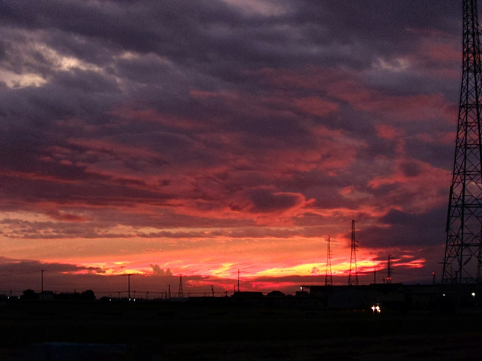夕焼けの空に広がる紫とオレンジの色合いとシルエットの電波塔