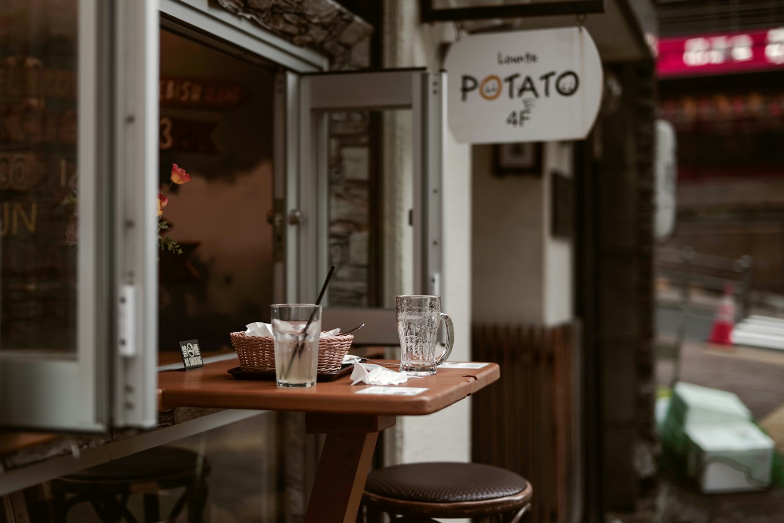 Ventana de café con mesa de madera y sillas comida y bebidas expuestas