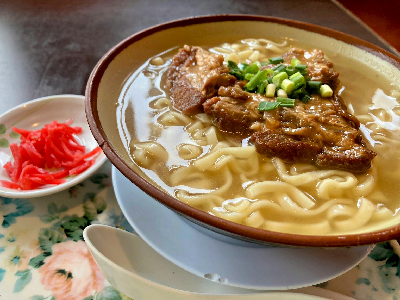 Tazón de ramen con carne y cebollas verdes servido con jengibre encurtido