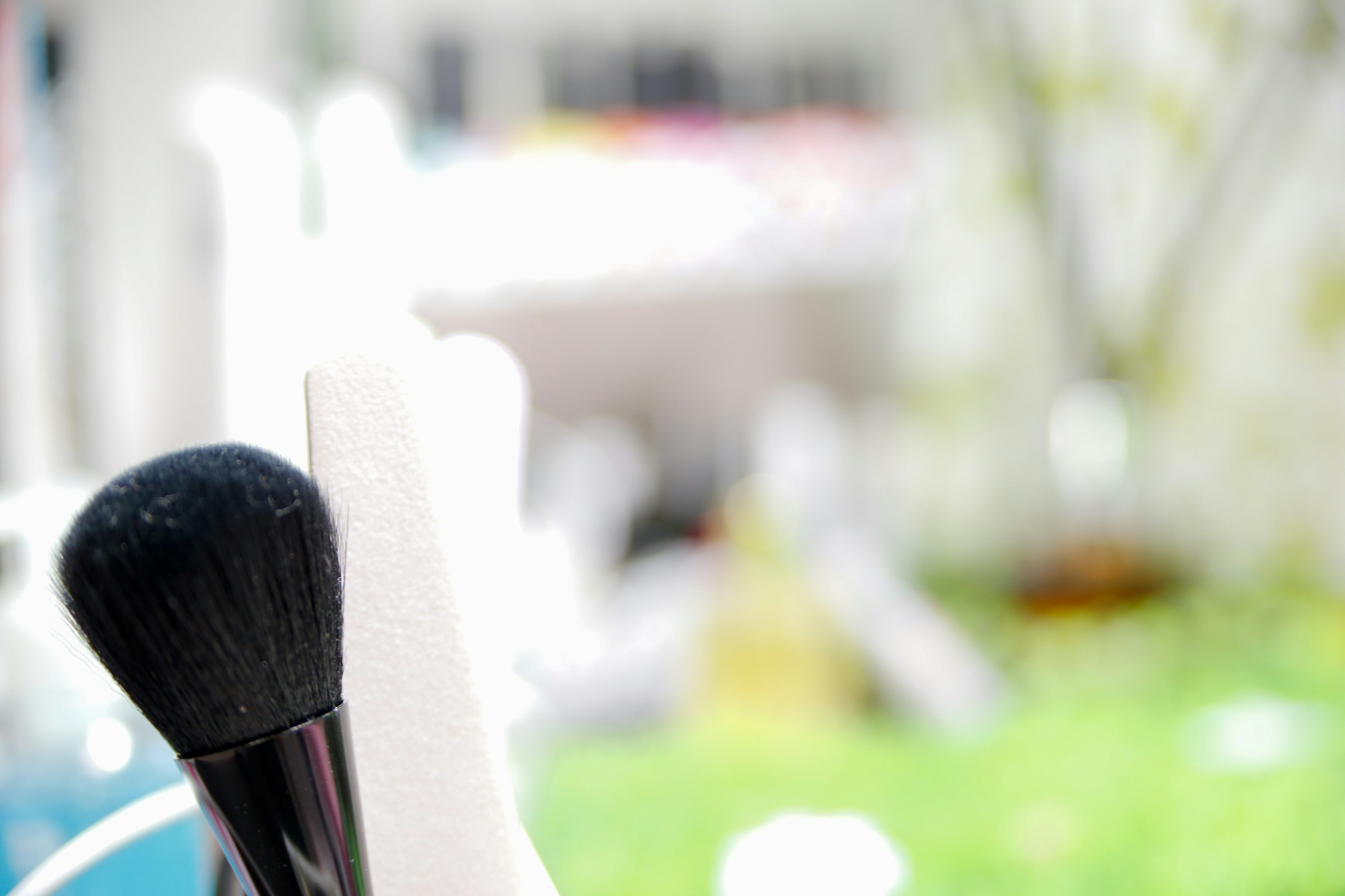 Make-up-Pinsel und Kosmetik-Accessoires vor einem Gartenhintergrund