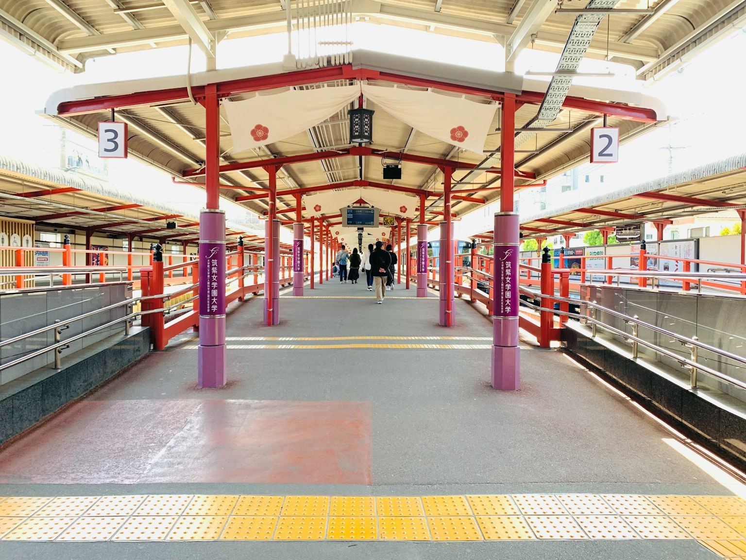Brightly colored train station platform with distinct pillars and lanterns