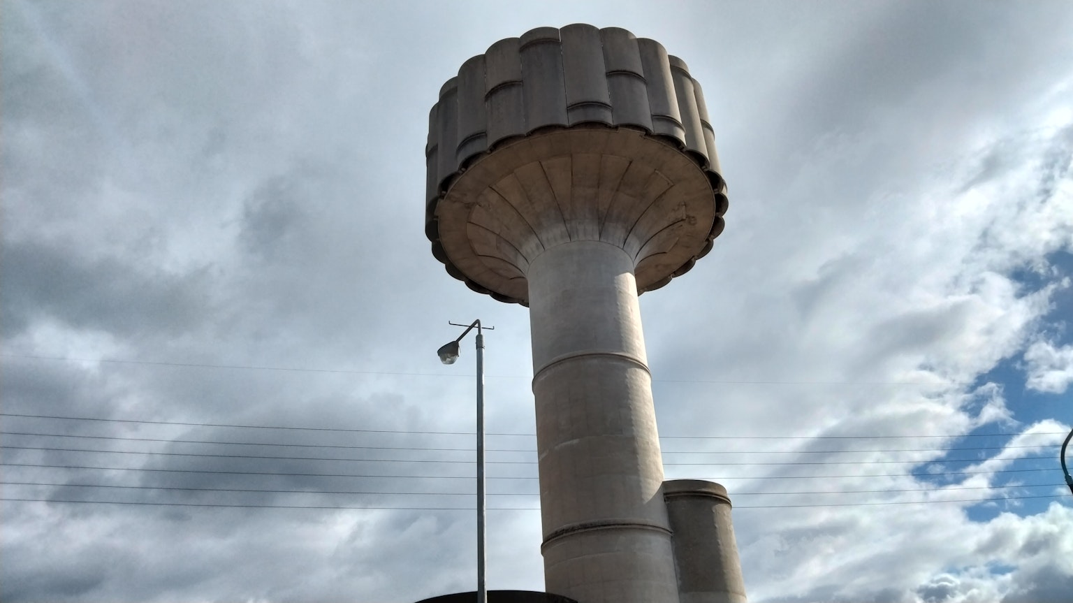 Diseño único de una torre de agua bajo un cielo azul con nubes