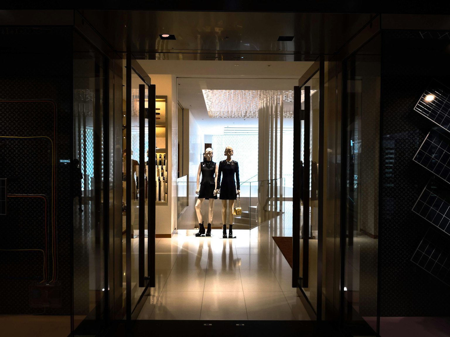 Immagine che presenta manichini all'ingresso di un negozio elegante con decorazioni moderne