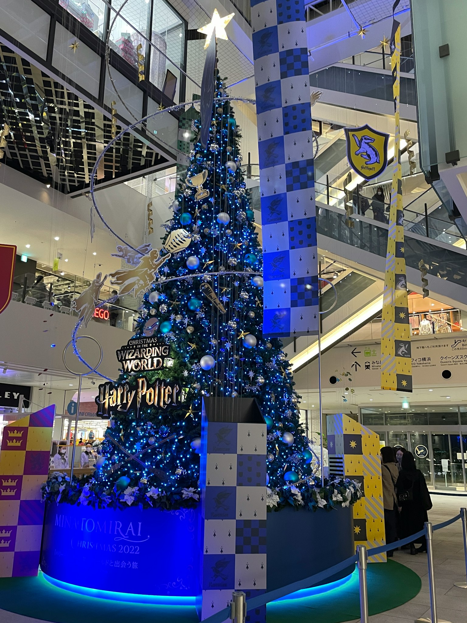 Un albero di Natale decorato in blu e bianco all'interno di un centro commerciale