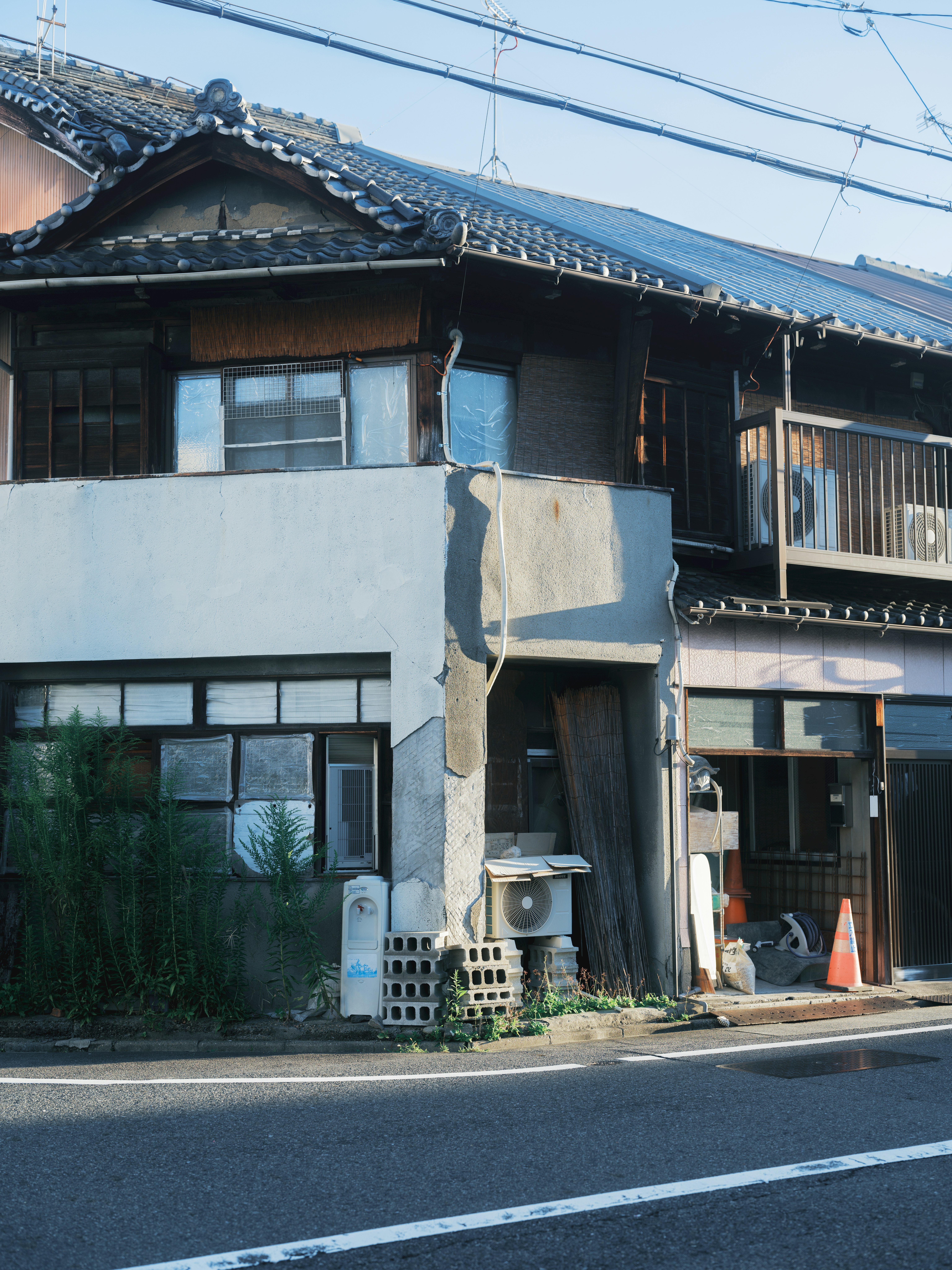 路地に面した古い町家の外観と軒先の看板