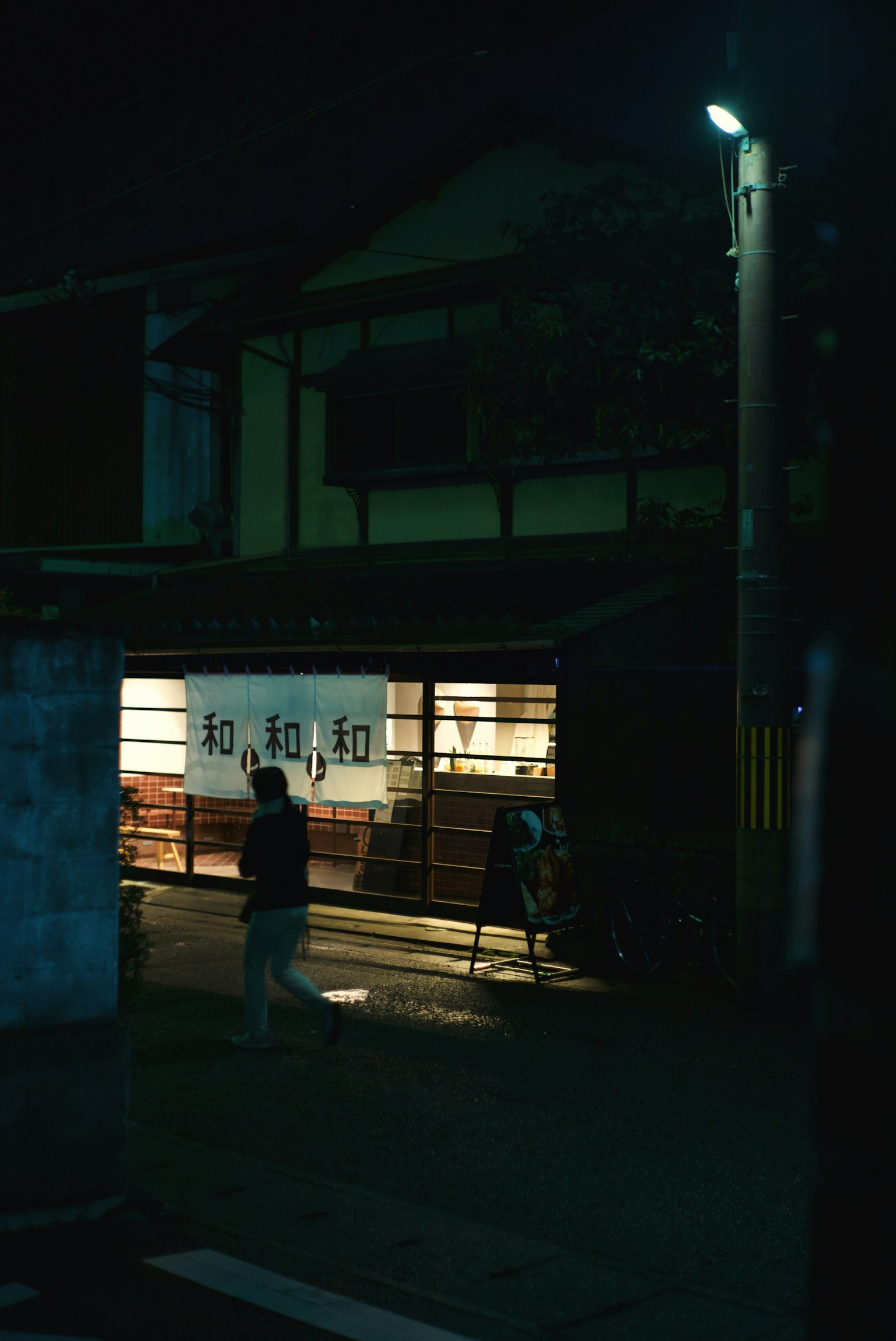 夜の街角にある伝統的な日本の建物と明かりが灯る窓