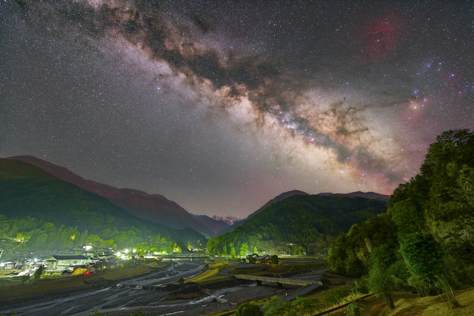 Stupendo paesaggio con montagne e fiume sotto un cielo stellato