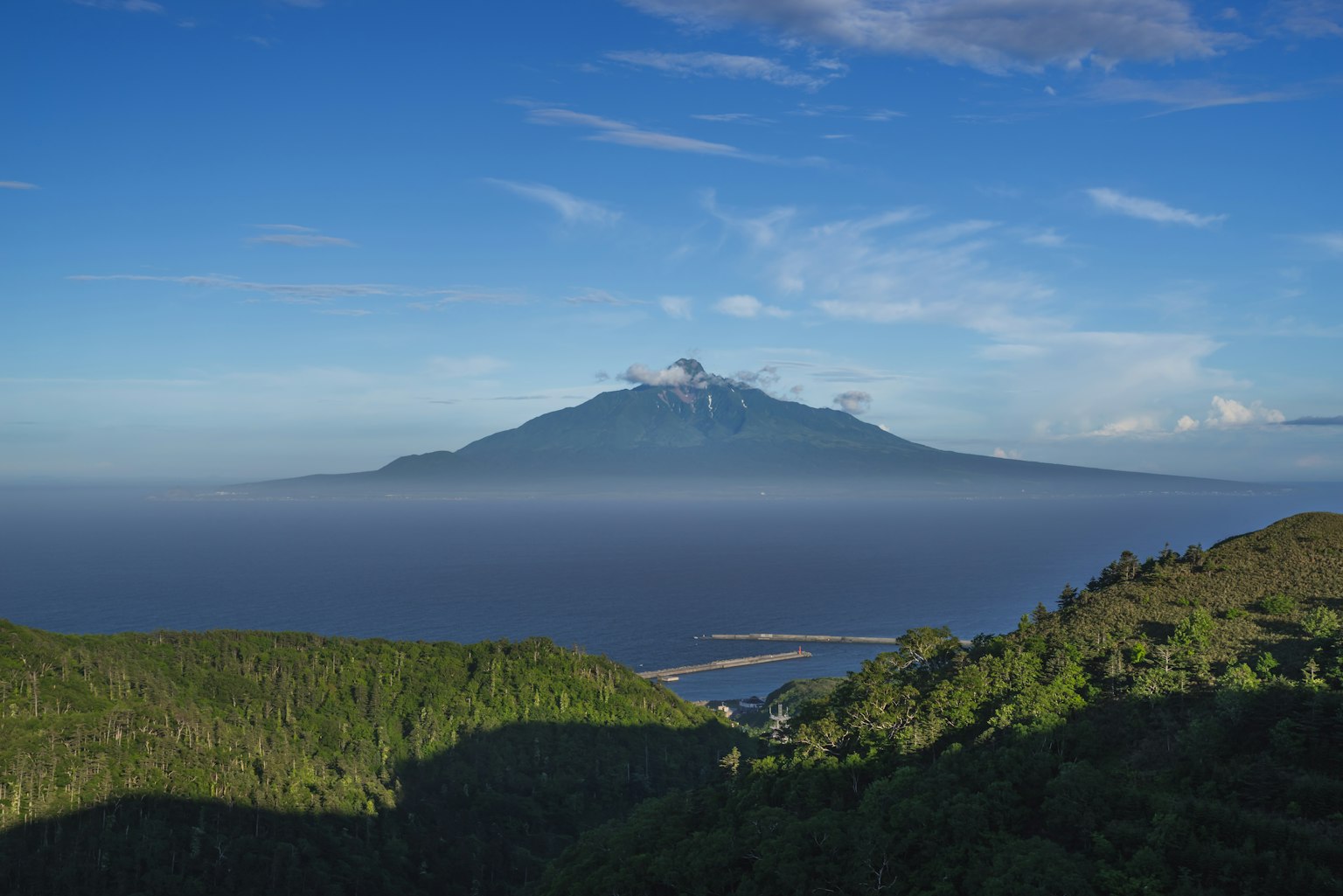 火山的美景被藍天和雲環繞郁郁葱葱的山脈和海洋