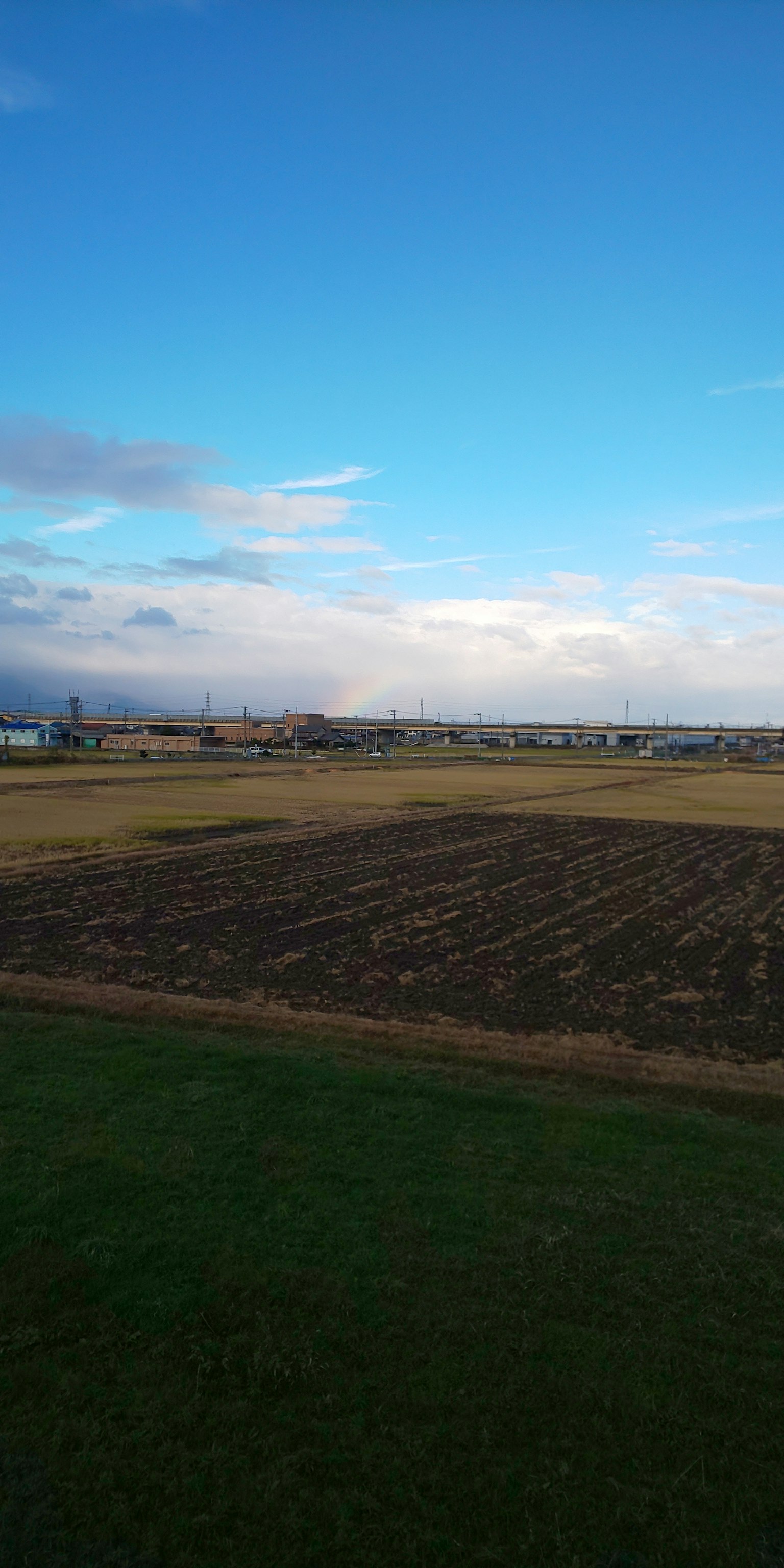 Paisaje de tierras agrícolas con campos arados bajo un cielo azul