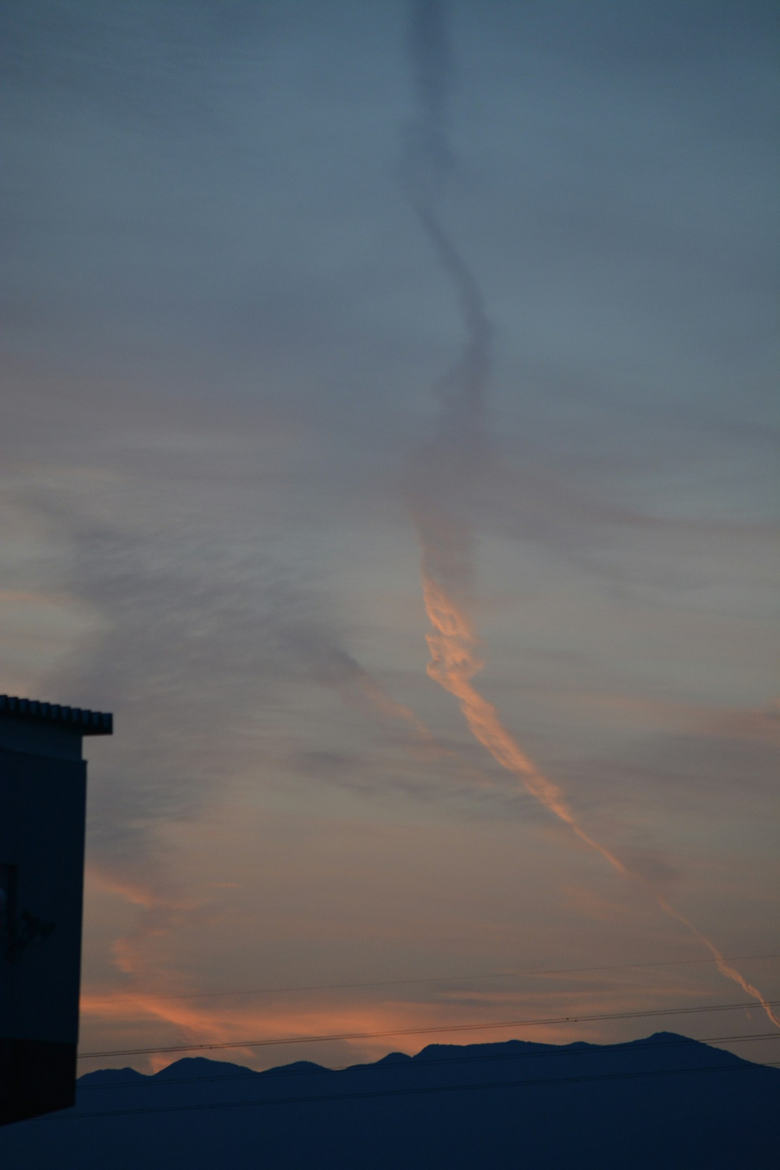 夕焼けの空に広がる雲と山のシルエット