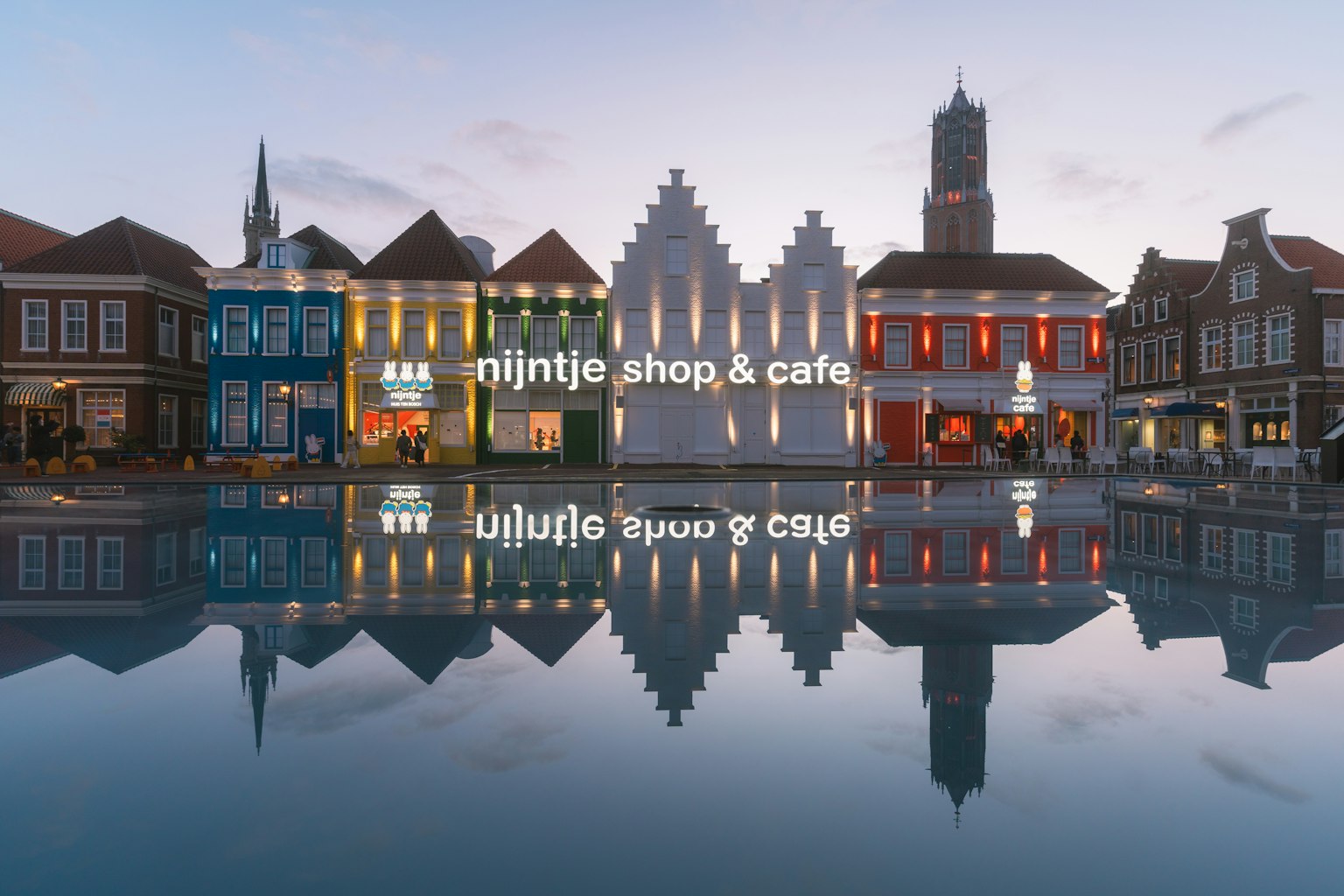 Scène de soirée magnifique avec le magasin et café Nijntje reflétés dans l'eau