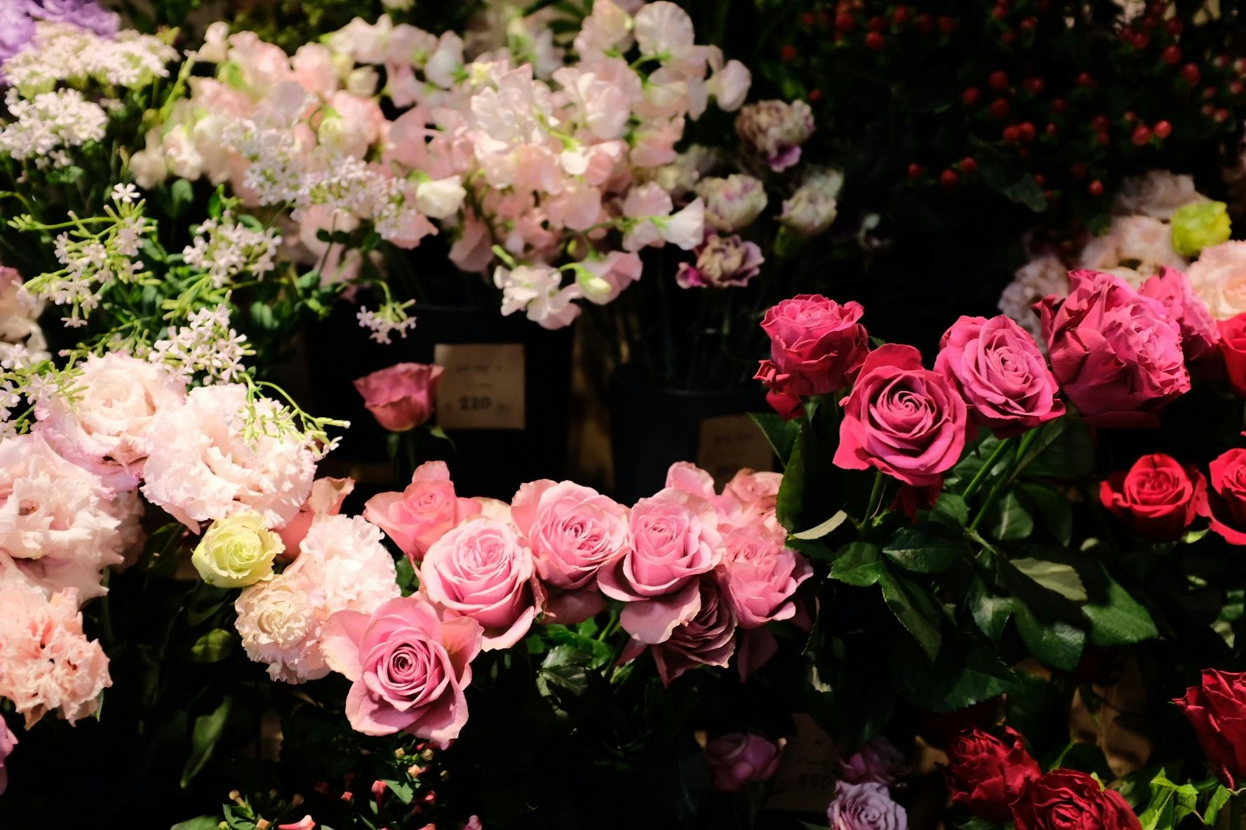 色とりどりのバラと花束が並ぶ花売り場のディスプレイ