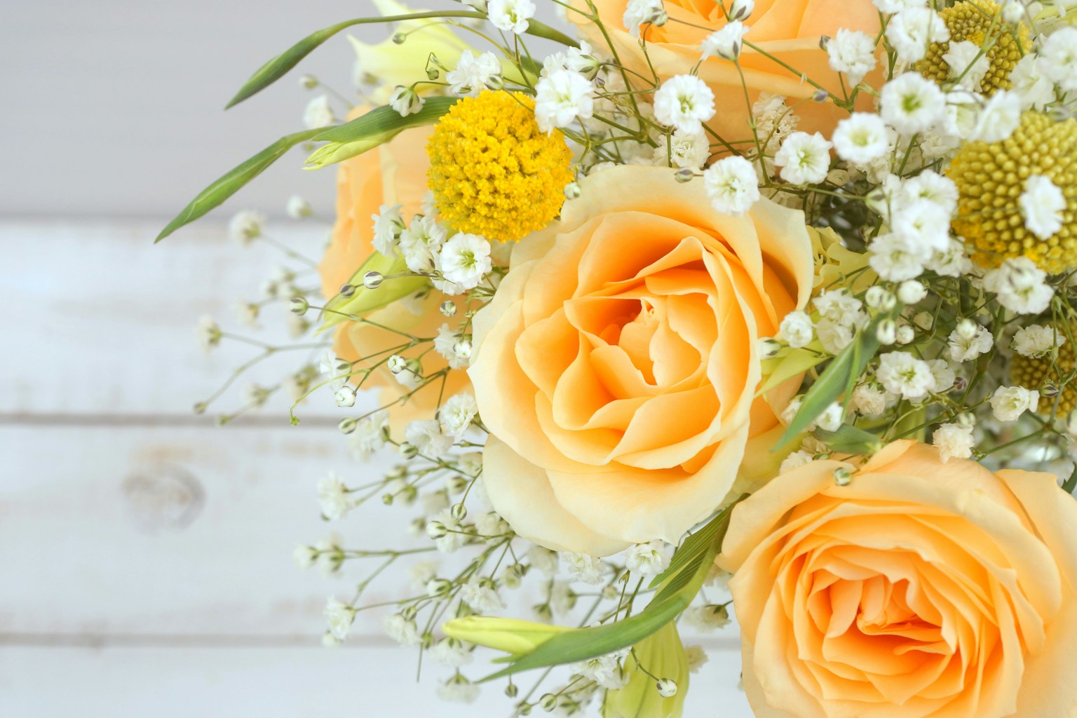 Bouquet avec des roses orange et de l'herbe à bébé blanche