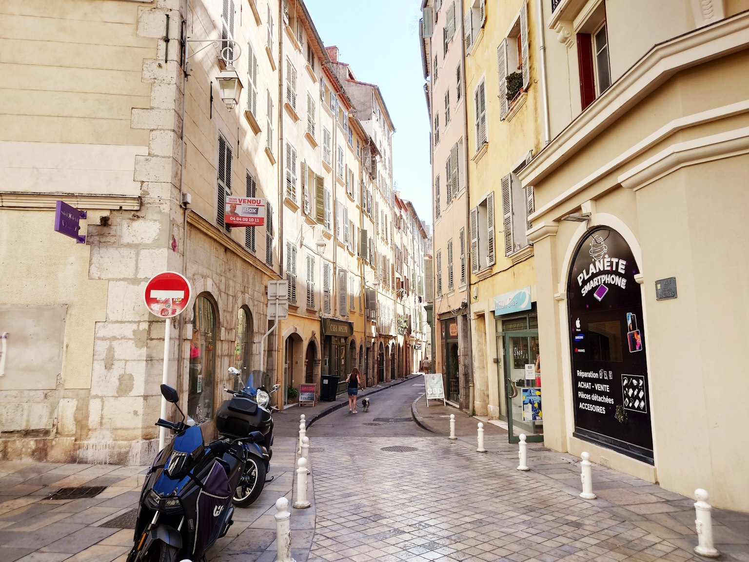 Strada stretta fiancheggiata da vecchi edifici e motociclette