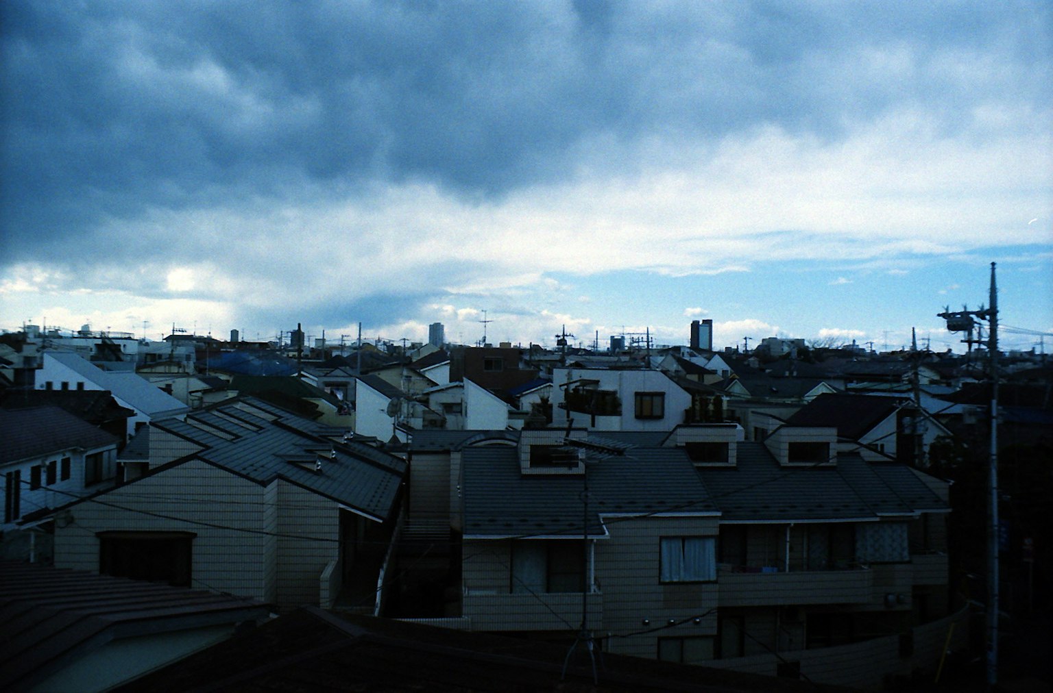 Urban landscape with blue sky and clouds featuring rooftops of houses