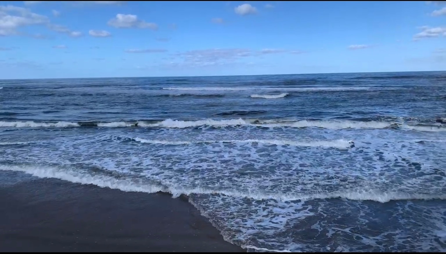 Gelombang laut biru di bawah langit cerah