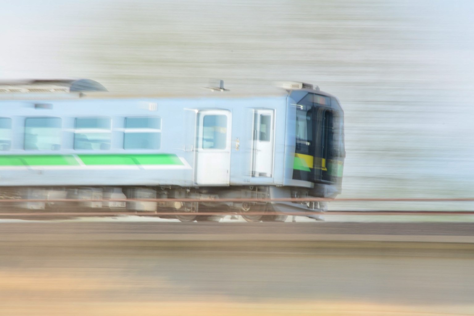 Imagen borrosa de un tren en movimiento con una línea verde distintiva