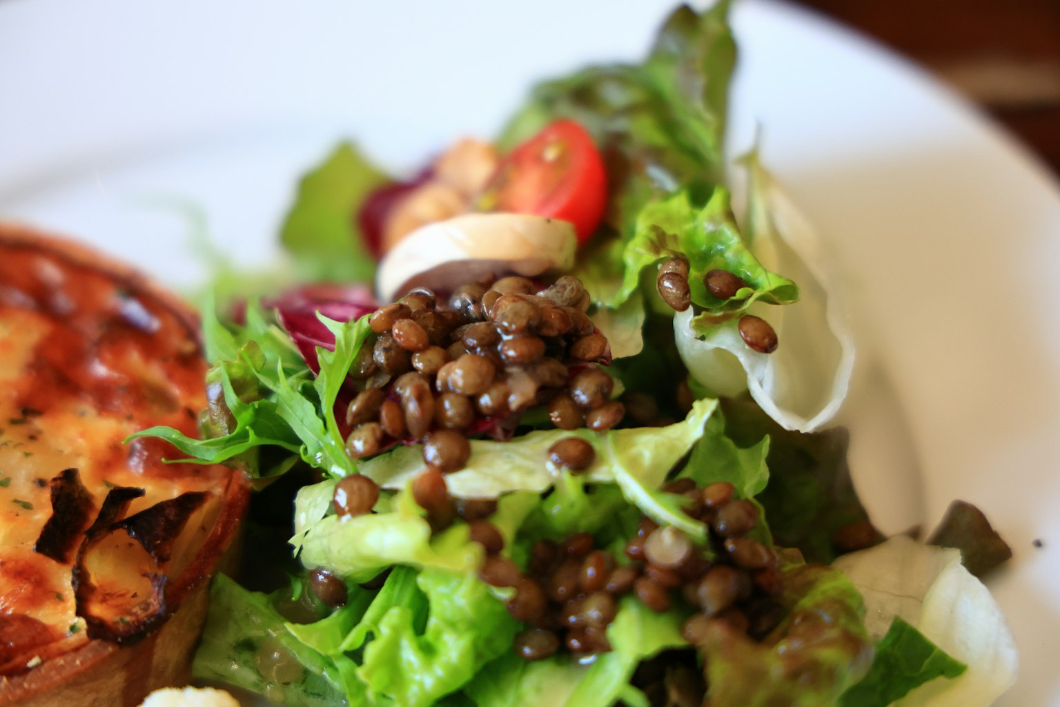 Một đĩa salad tươi với đậu lăng và cà chua bi