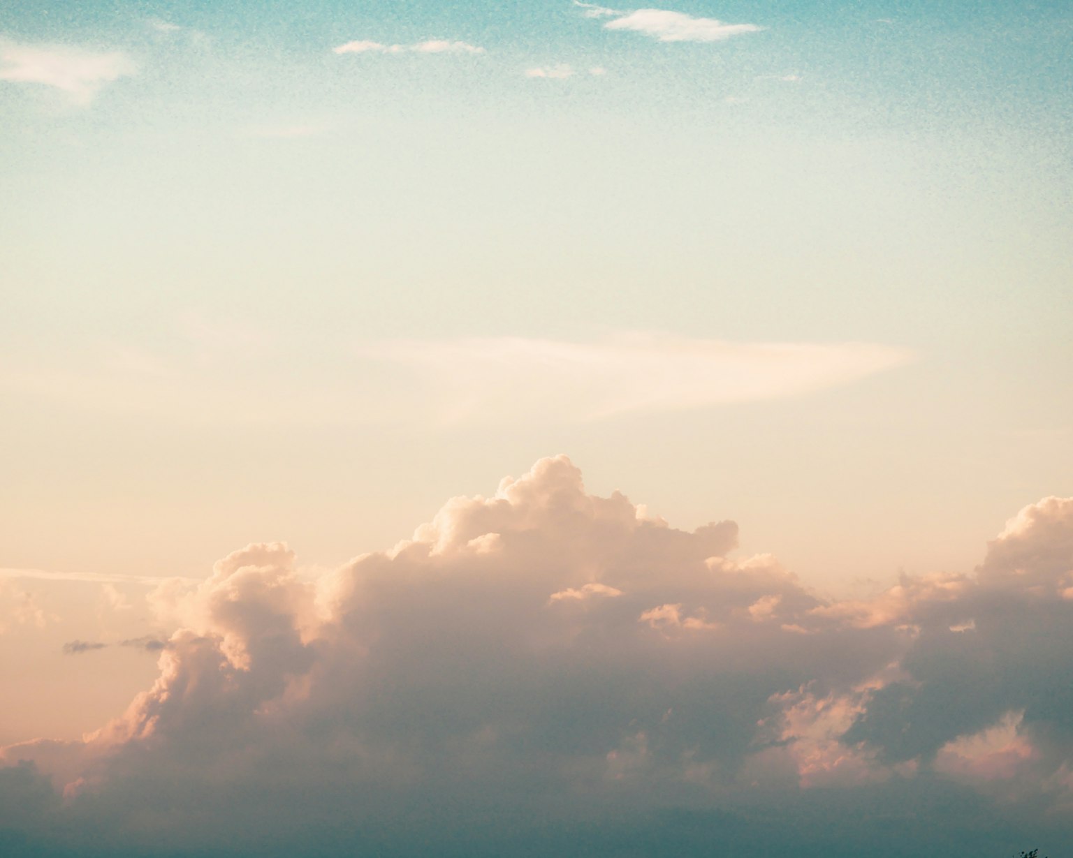 Nubes suaves en un cielo azul tranquilo con tonos cálidos de atardecer