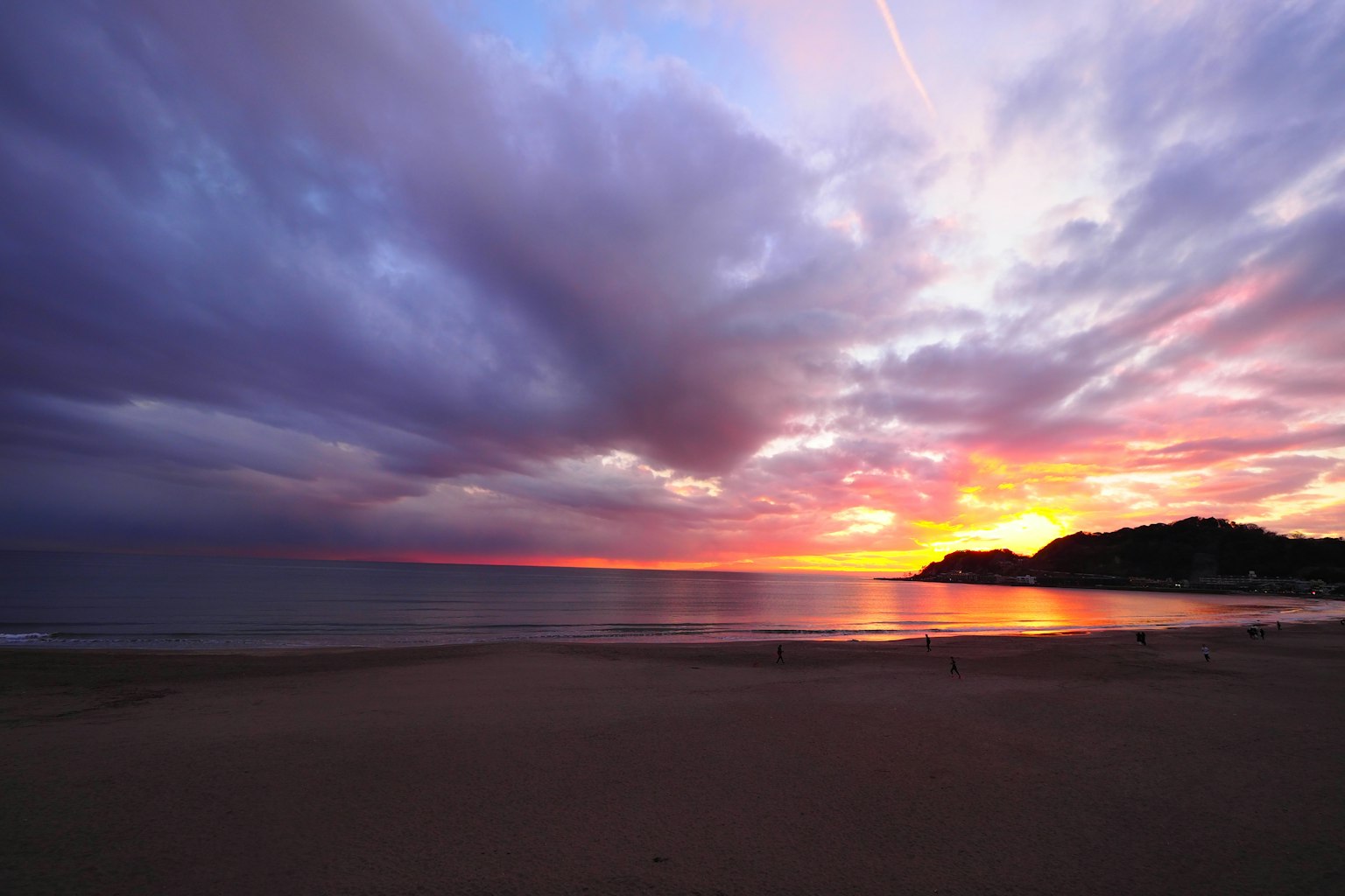 Coucher de soleil côtier avec des couleurs vives et des eaux calmes