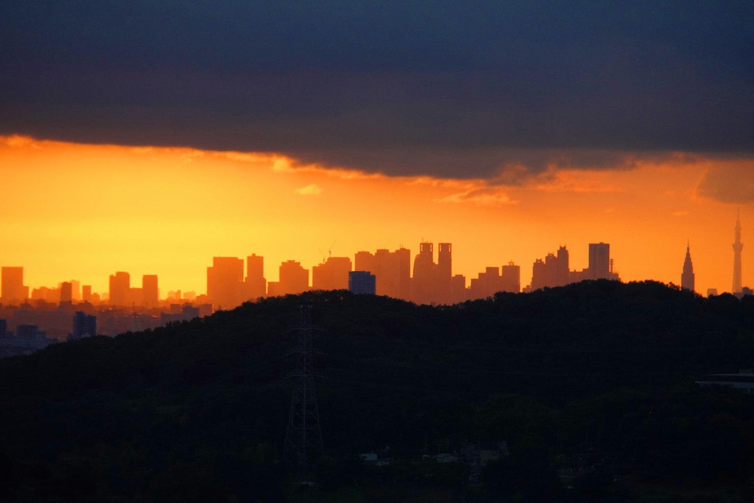 Silhouette di un'urbanizzazione al tramonto con colline