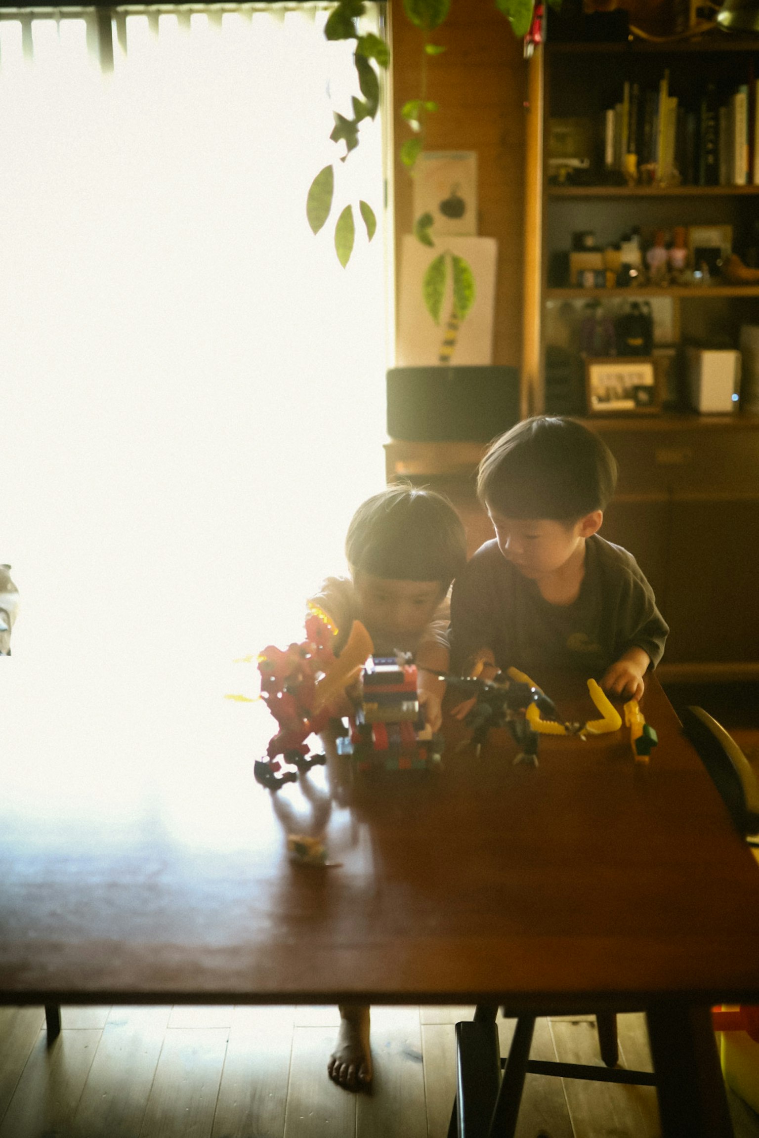 子供たちがテーブルでおもちゃの車で遊んでいる様子