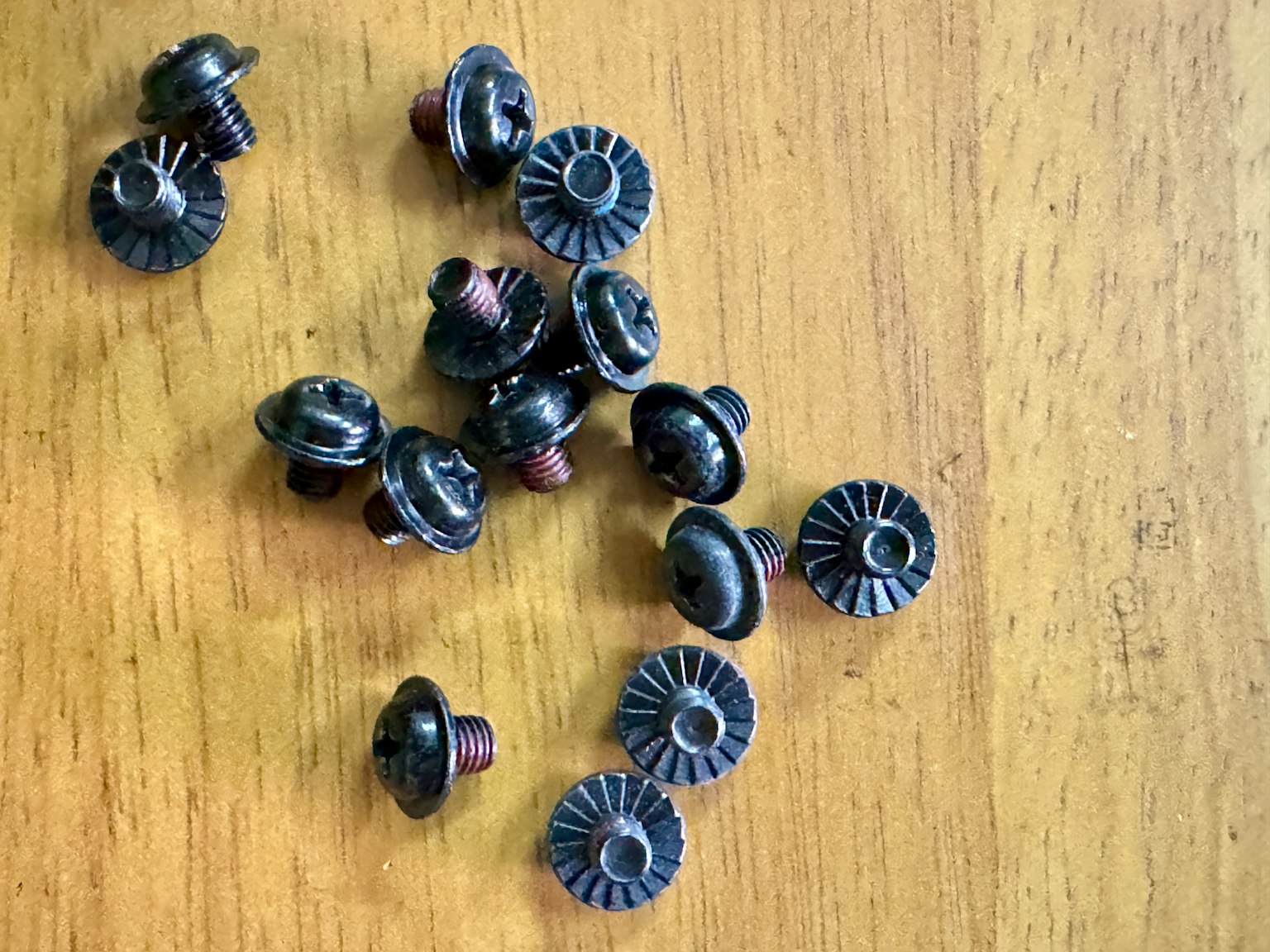 Kleine schwarze Knöpfe, die auf einem Holztisch verstreut sind