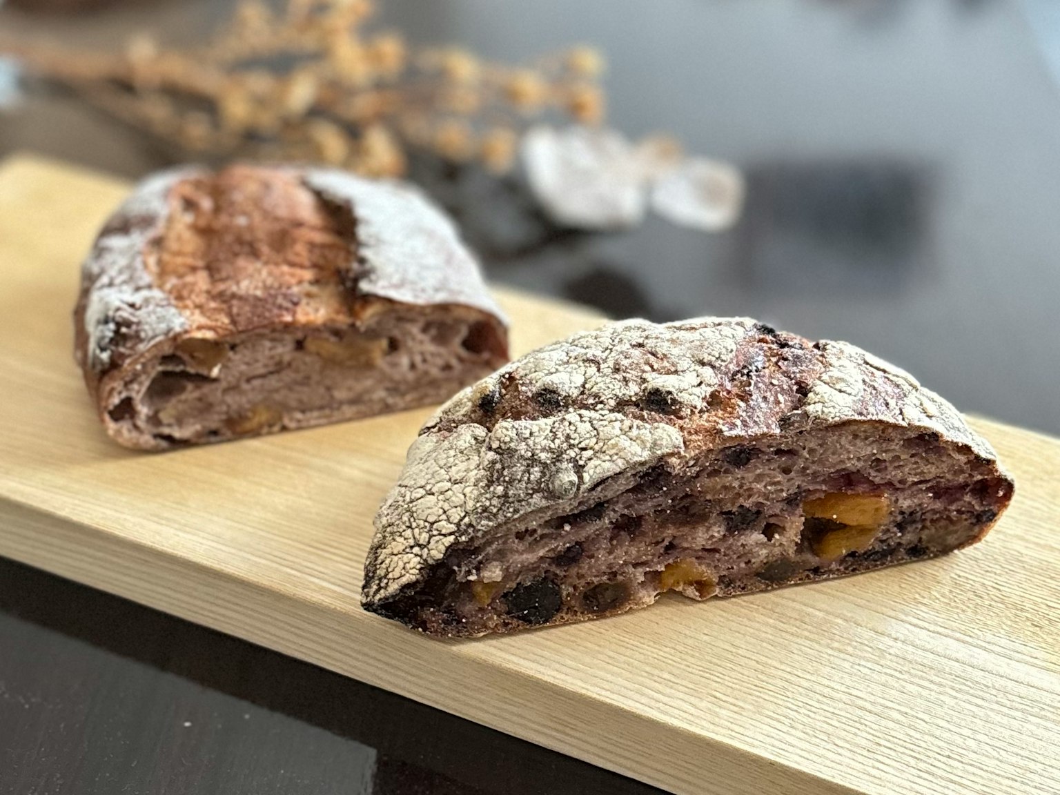 A hard bread loaf and its cross-section on a wooden board
