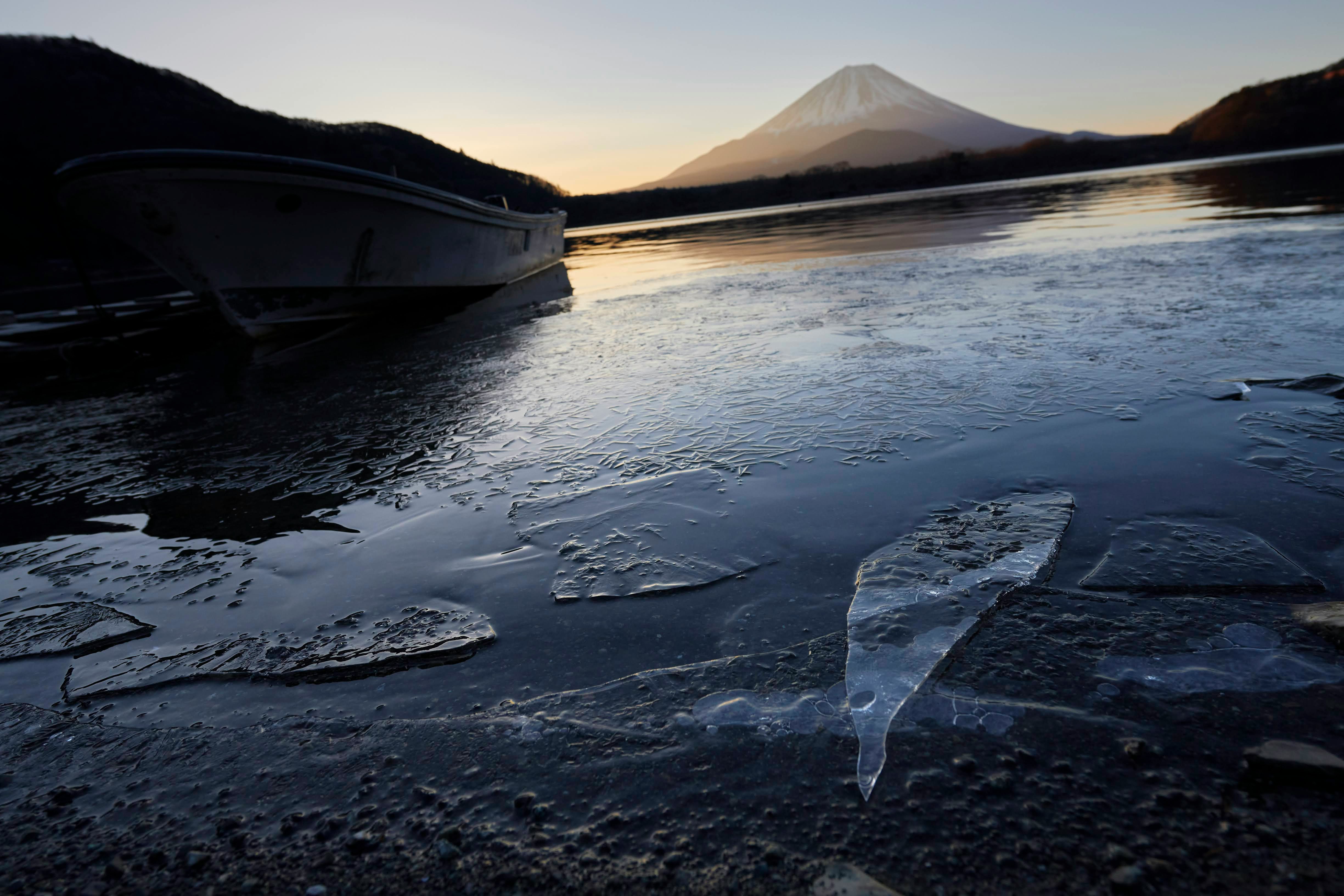 夕暮れの海岸で波打ち際に打ち上げられた氷