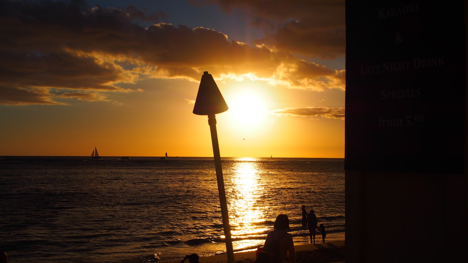 Silueta de un cartel contra un atardecer sobre el mar