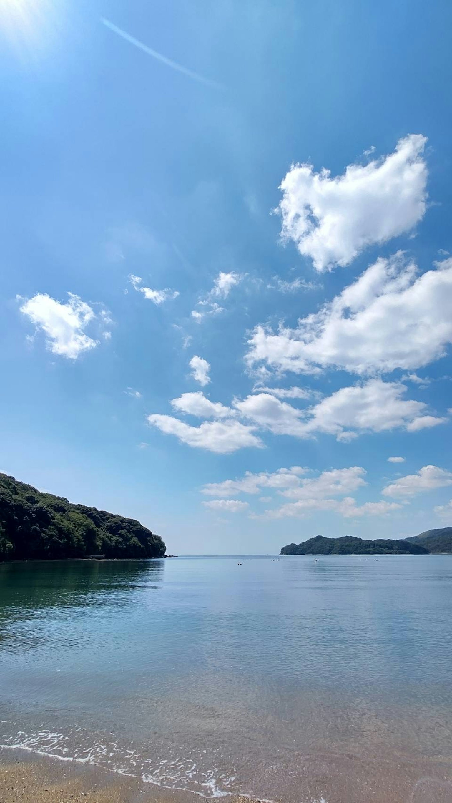 Vue de plage sereine avec ciel bleu et nuages moelleux