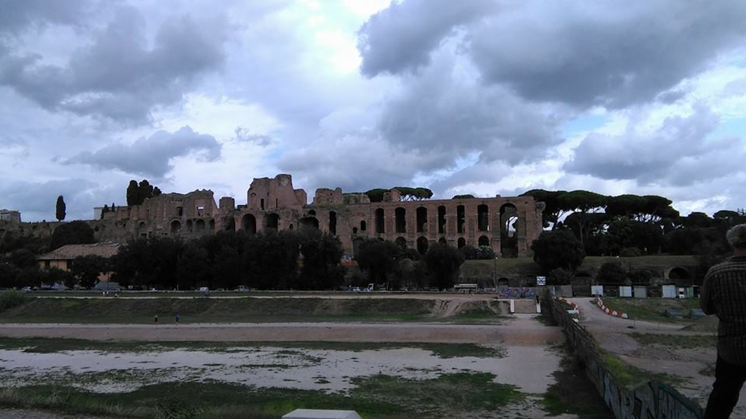 Paesaggio con rovine romane antiche sotto un cielo nuvoloso con vegetazione