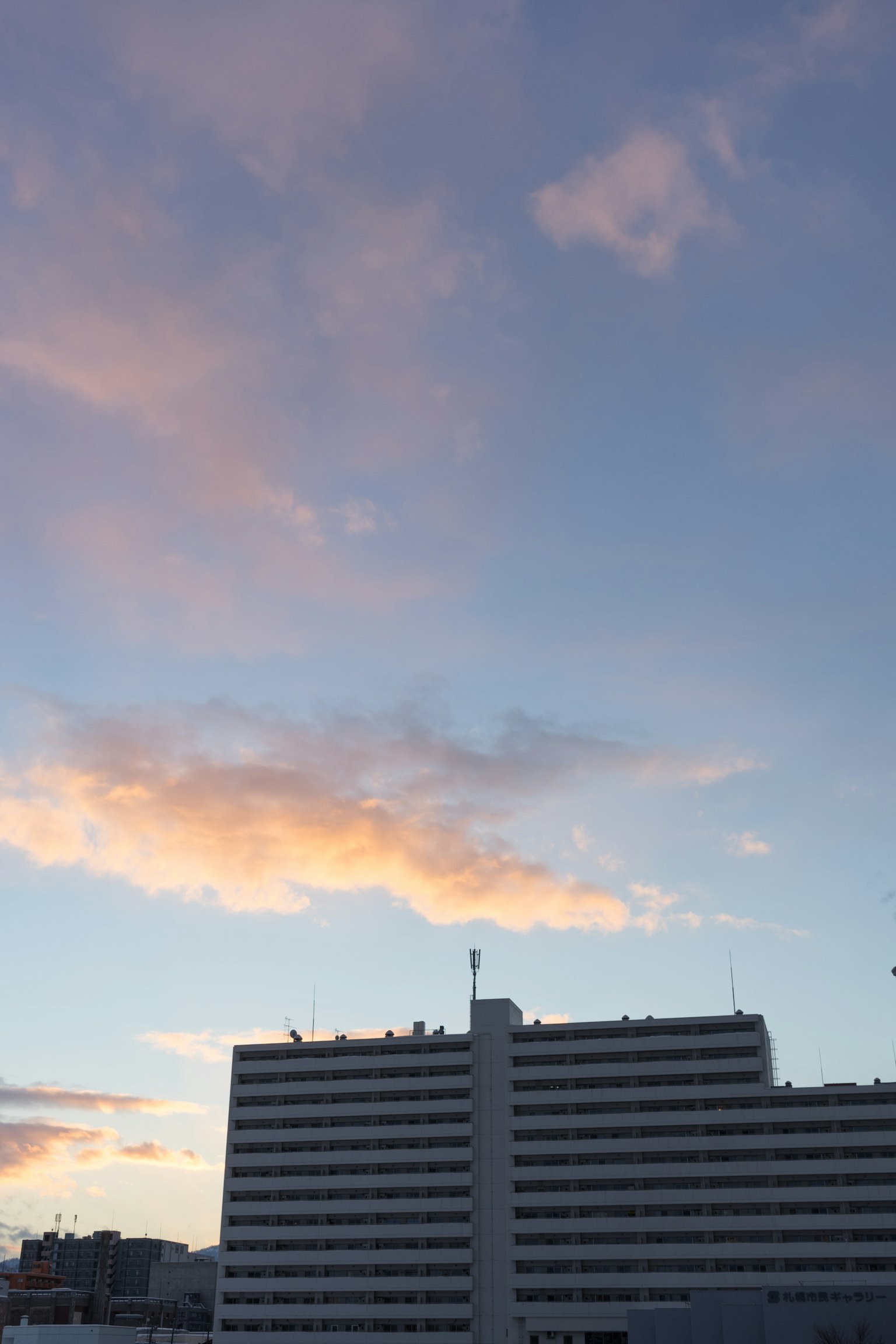 Silhouette of a white building against a sunset sky