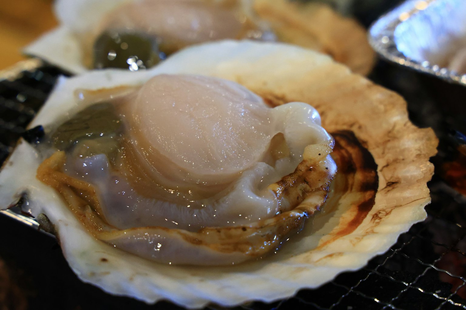 Coquille Saint-Jacques fraîche sur une coquille grillée