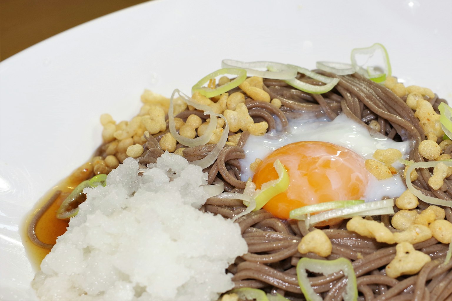 Sepiring mie soba dengan telur mentah dan lobak parut