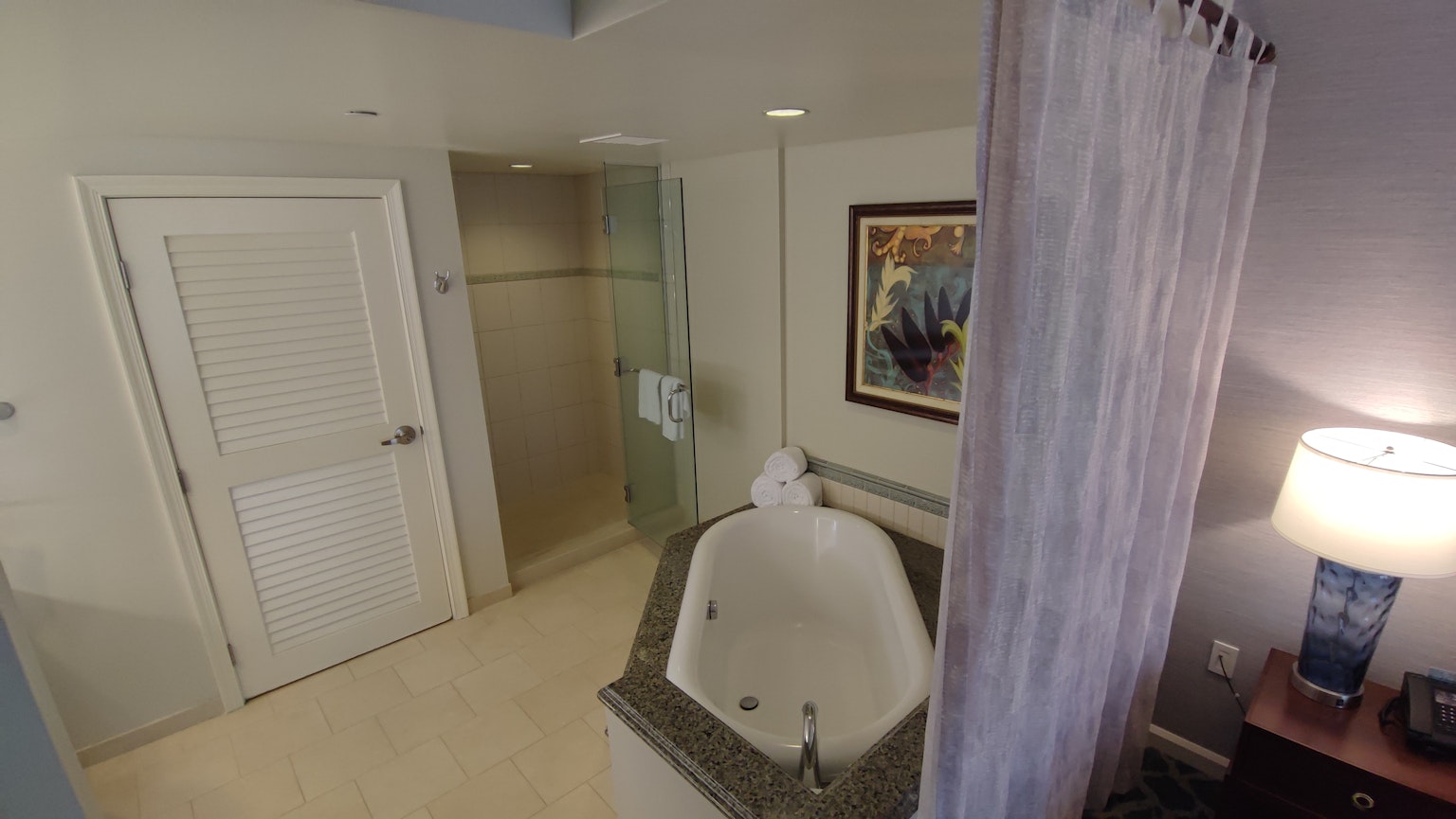Intérieur d'une salle de bain avec jacuzzi et douche Œuvre d'art au mur et table de nuit
