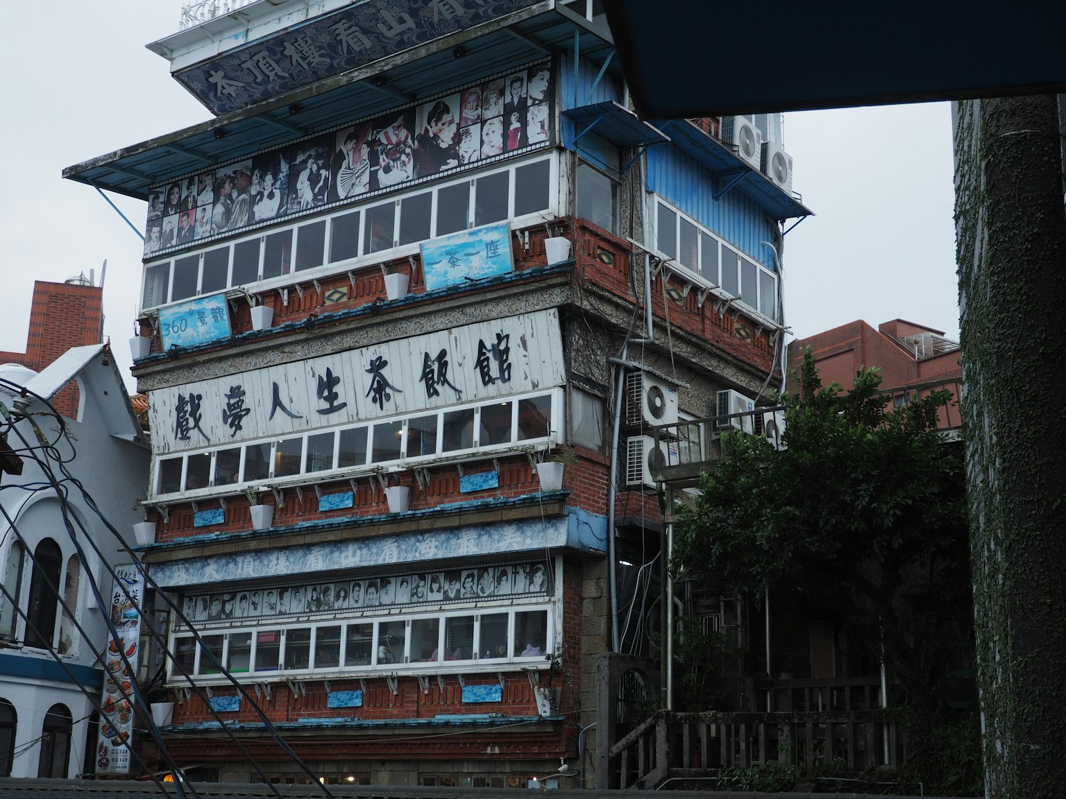 Bâtiment coloré à plusieurs étages avec des fresques artistiques et une végétation environnante