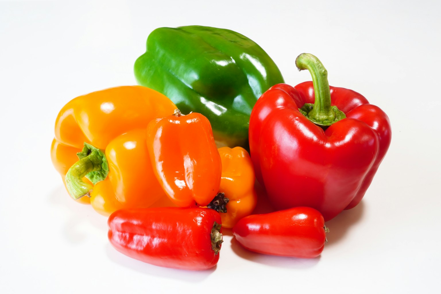 Poivrons colorés disposés sur un fond blanc