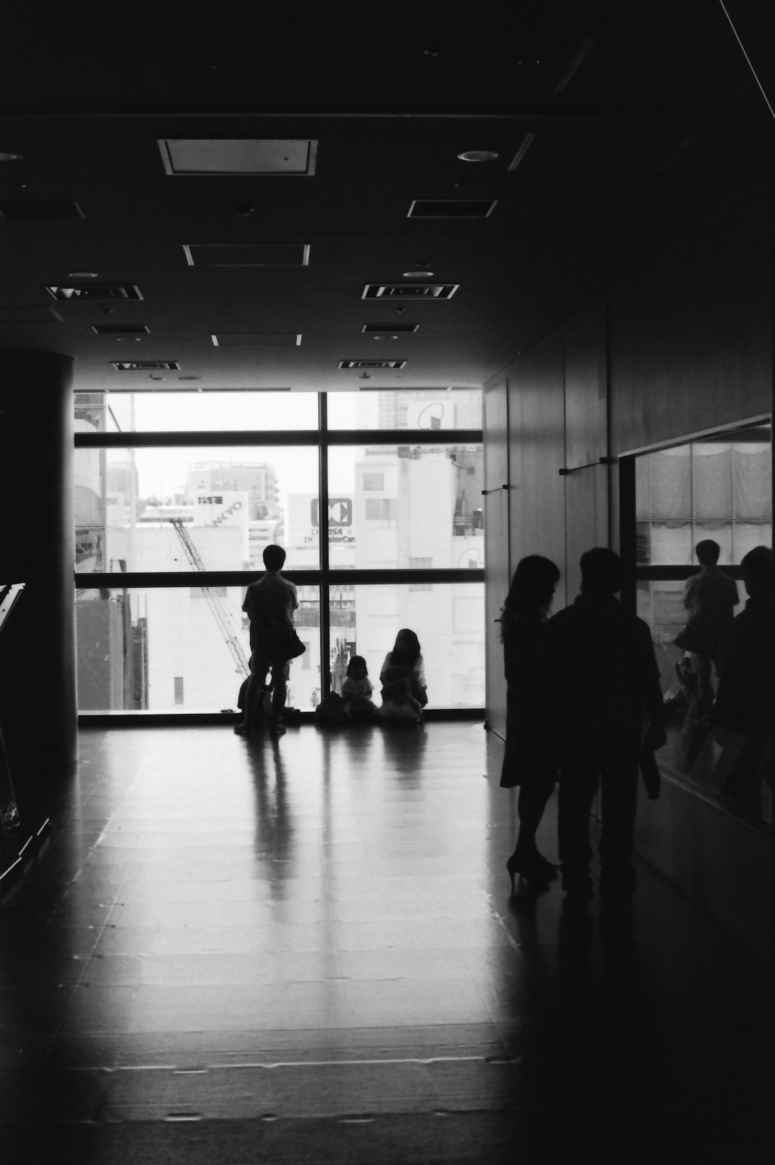 Silhouettes of people standing near a window in a black and white space