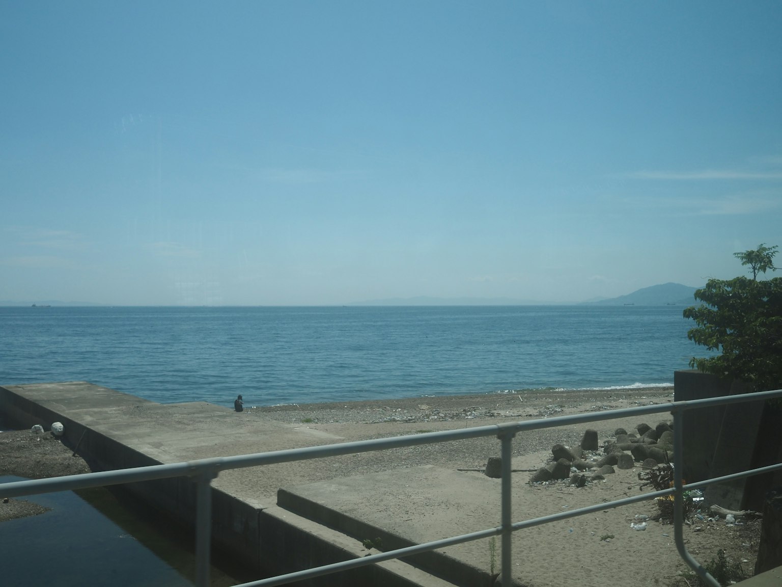 วิวชายหาดที่มีทะเลสีน้ำเงินสงบและท้องฟ้าใส
