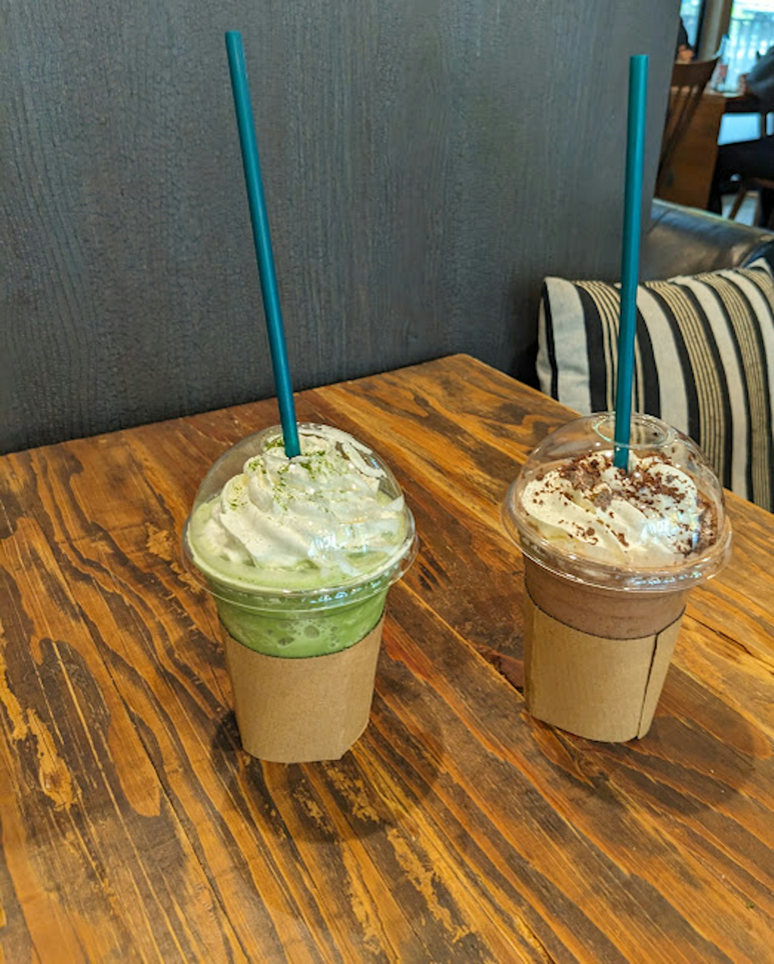 Frappuccino al tè verde e al cioccolato su un tavolo di legno