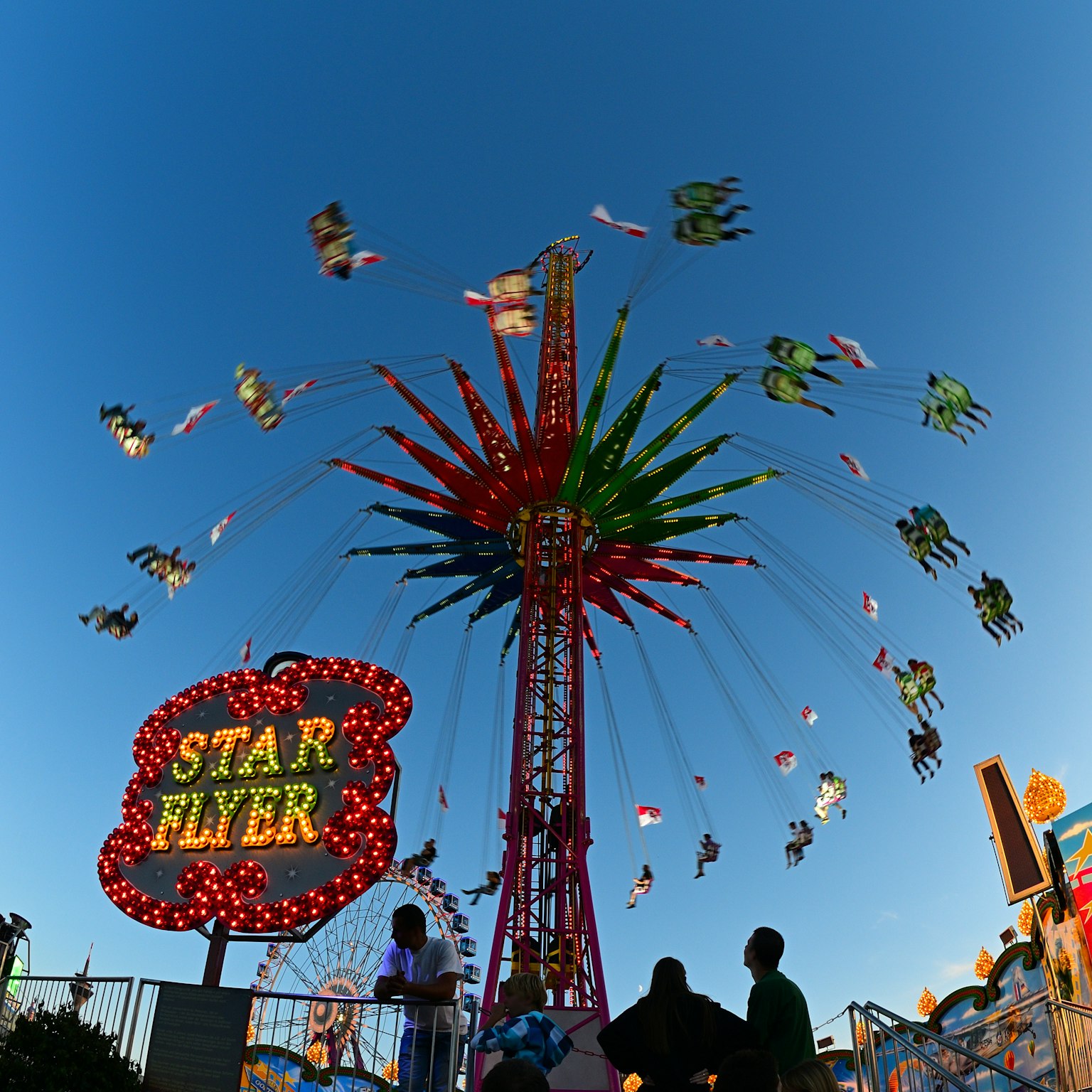 Attraction Star Flyer avec des lumières colorées et des gens s'amusant