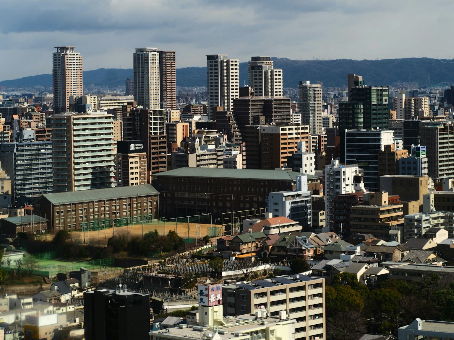 Urban skyline featuring tall buildings with distant mountains in the background